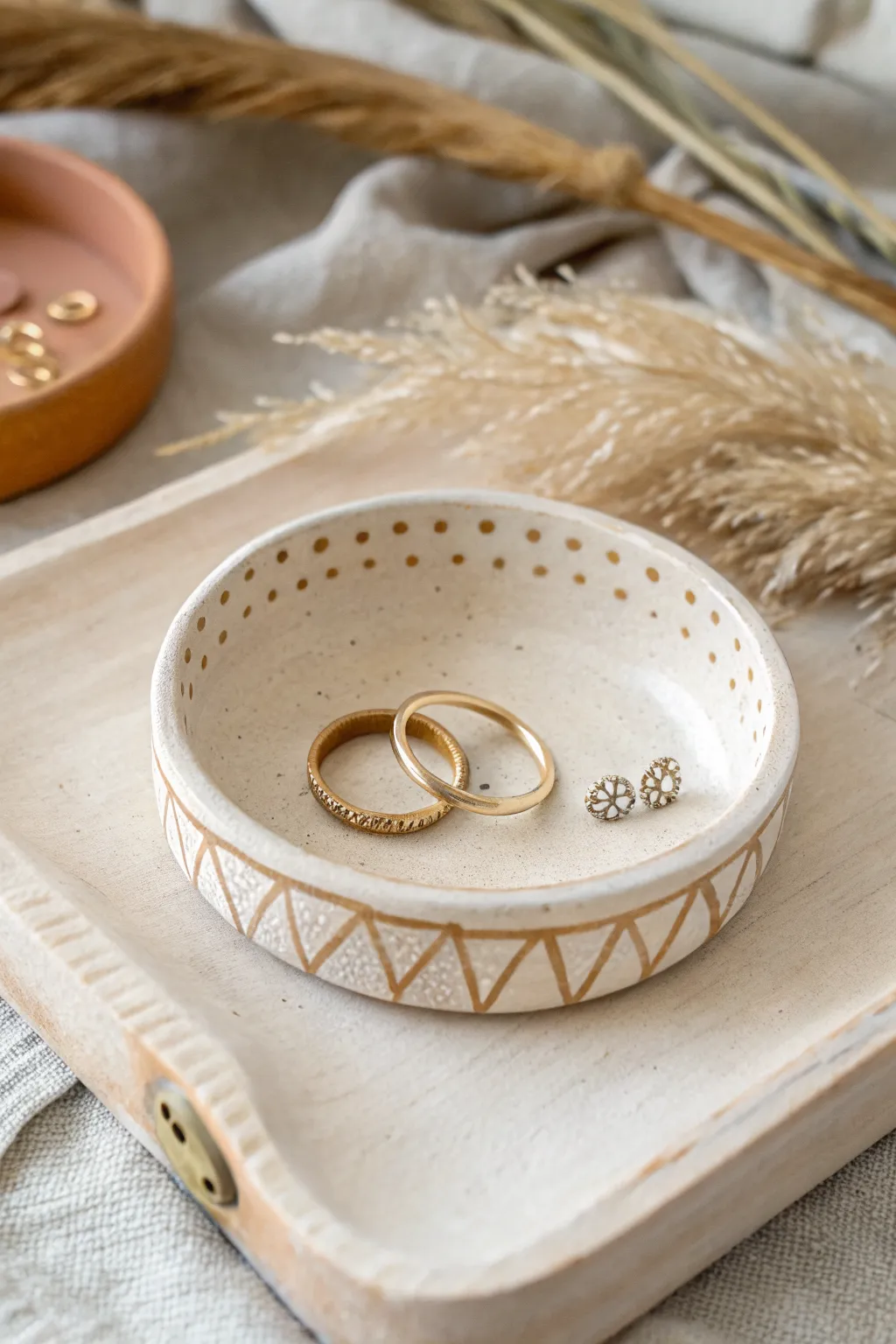 Minimal stamped air dry clay trinket dish in soft neutrals, styled with rings and a key