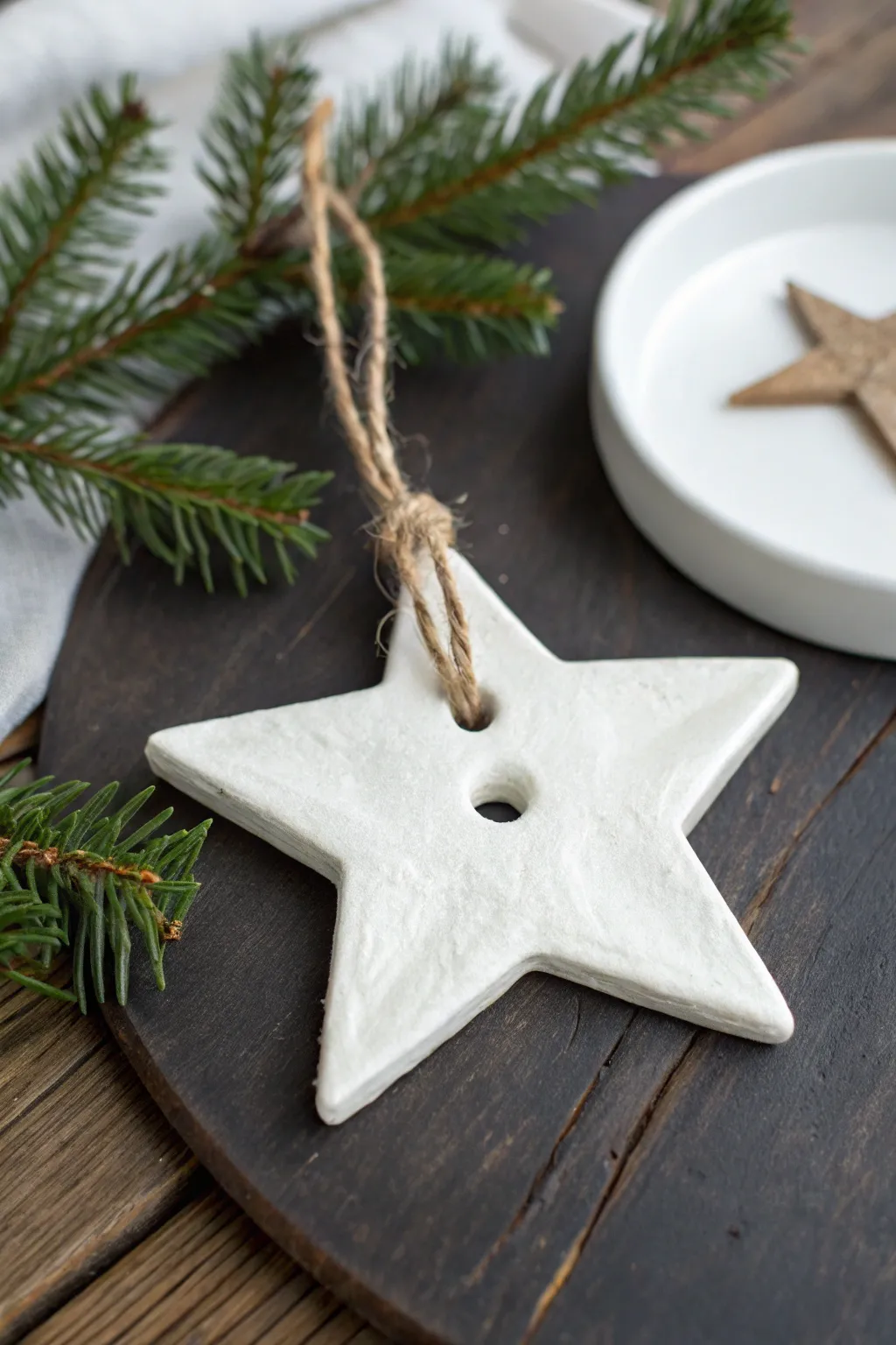 Simple air dry clay star ornament with twine on rustic wood, cozy minimalist holiday charm