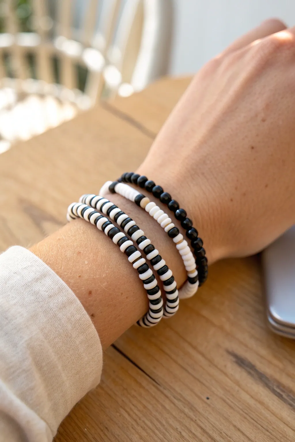 Classic black and white heishi stack with simple patterns, clean lines, and modern contrast
