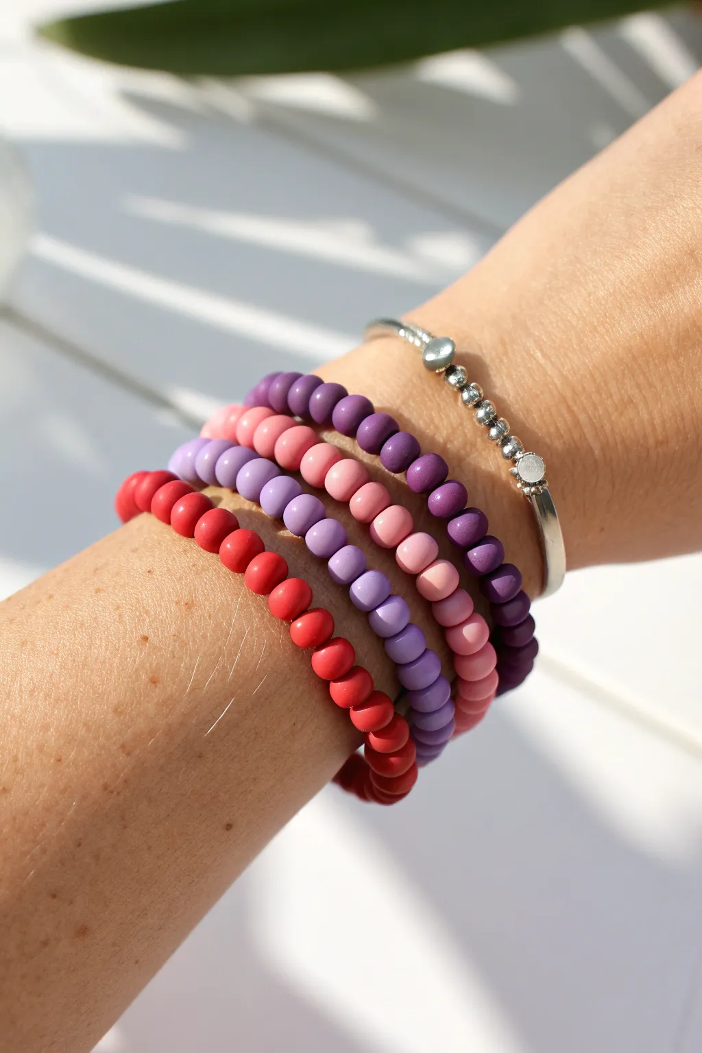 Three classic rainbow clay bead bracelets stacked with tiny spacers for a clean, boho-minimal look.