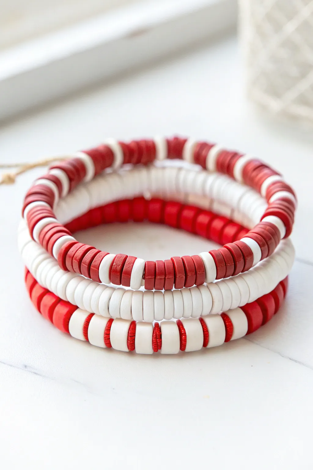 Candy cane stripe bracelet stack in red and white heishi beads, minimal, festive, and handmade.