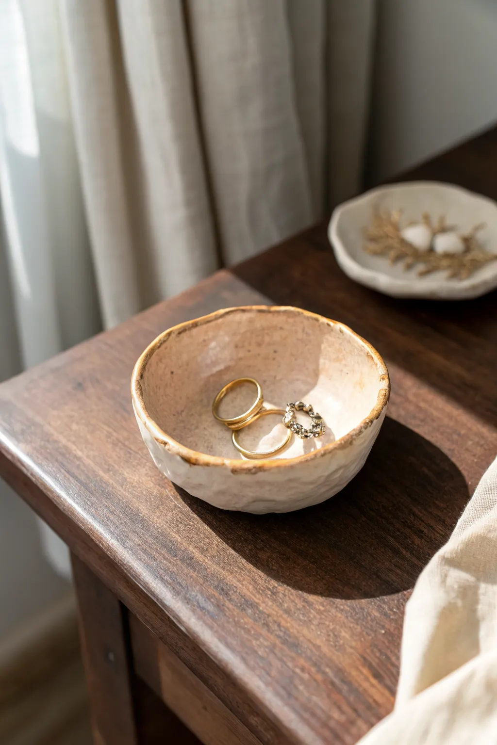Pastel pinch pot trinket bowl holding rings and tiny beads, minimalist Scandinavian boho vibe.