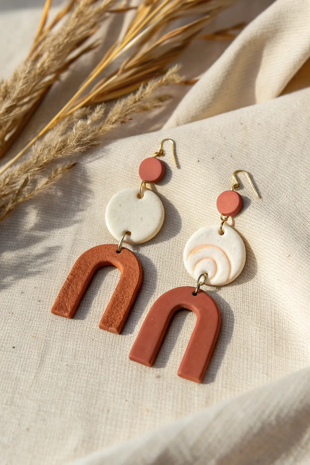 Minimal polymer clay statement earrings with matte finish, simple arches in earthy tones.