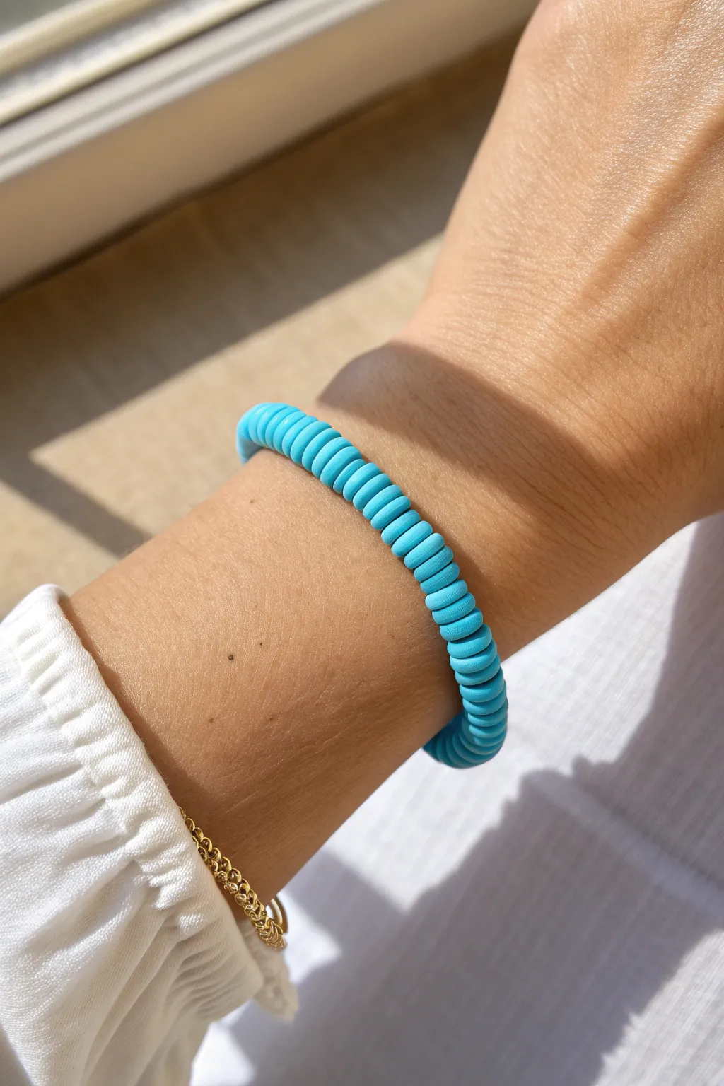 Classic monochrome blue heishi bracelet on wrist, crisp minimalist styling with natural contrast