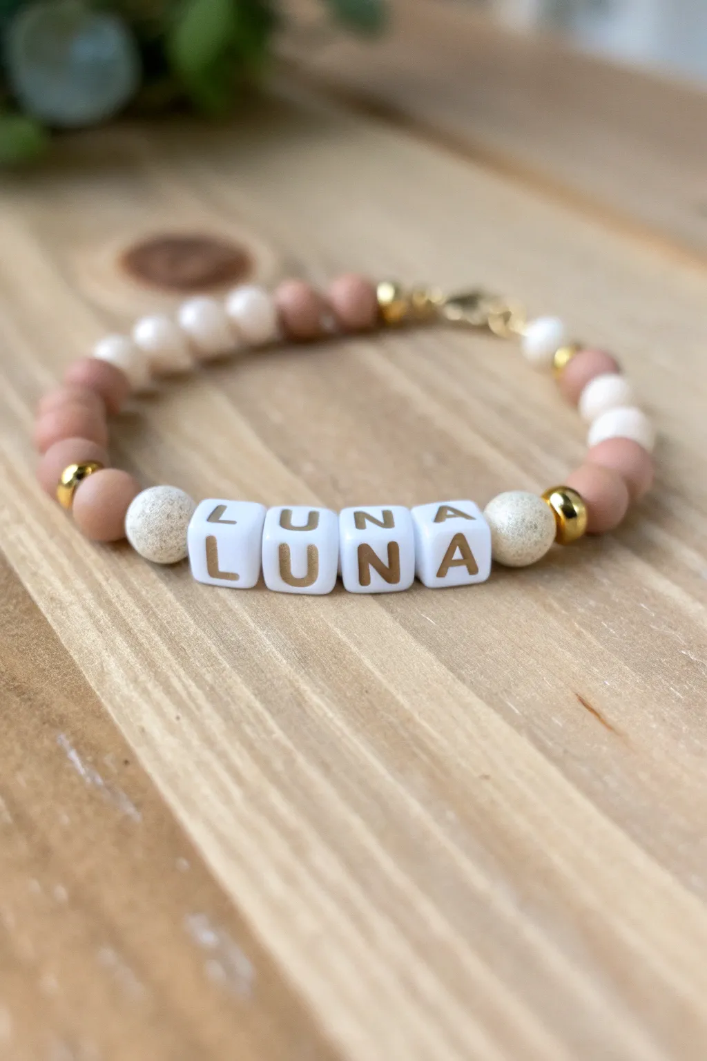 Classic name centerpiece clay bead bracelet in neutral tones with letter beads and gold spacers