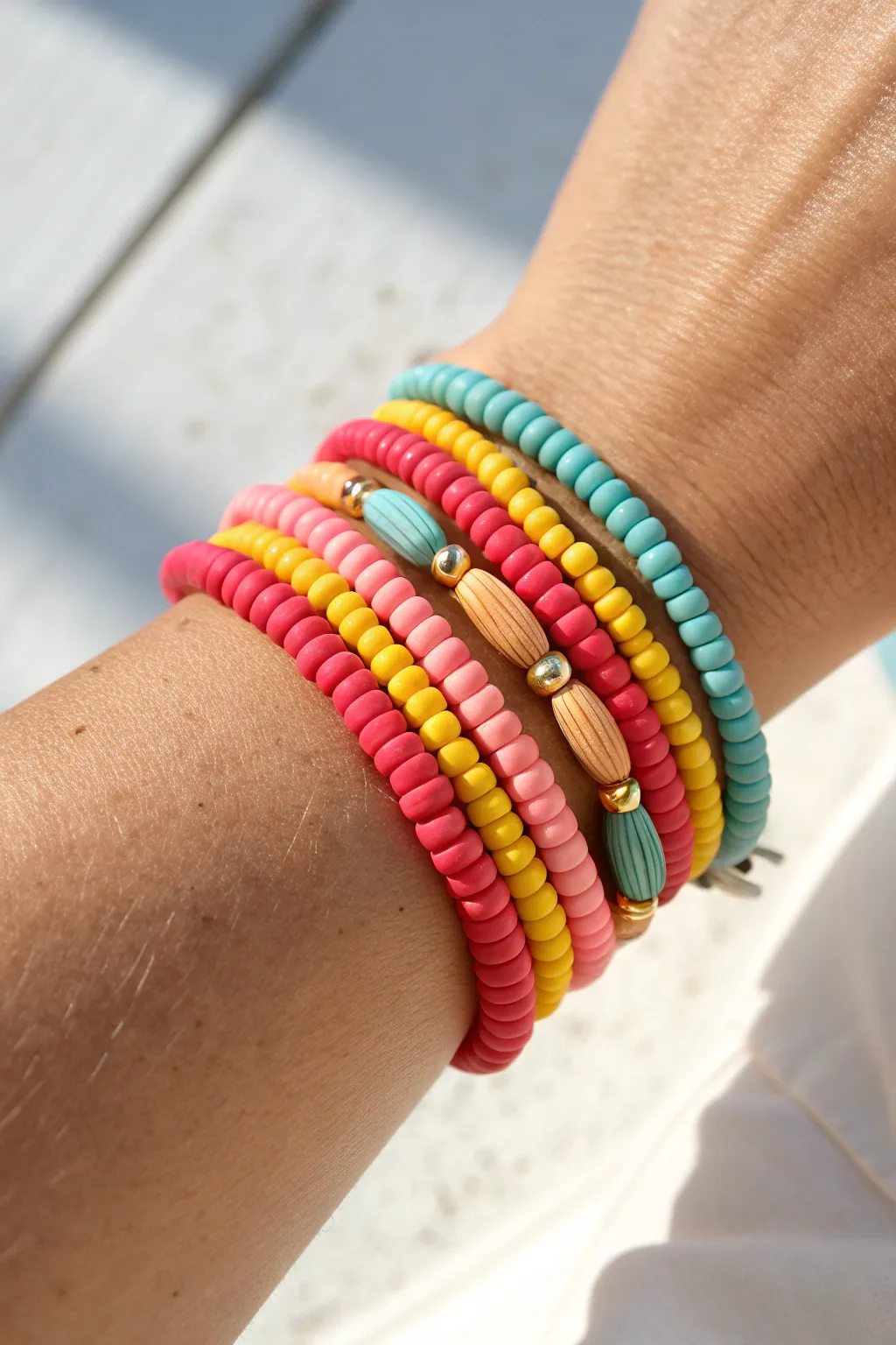 Classic bright heishi summer stack in coral, teal, yellow and hot pink, sunlit and simple.