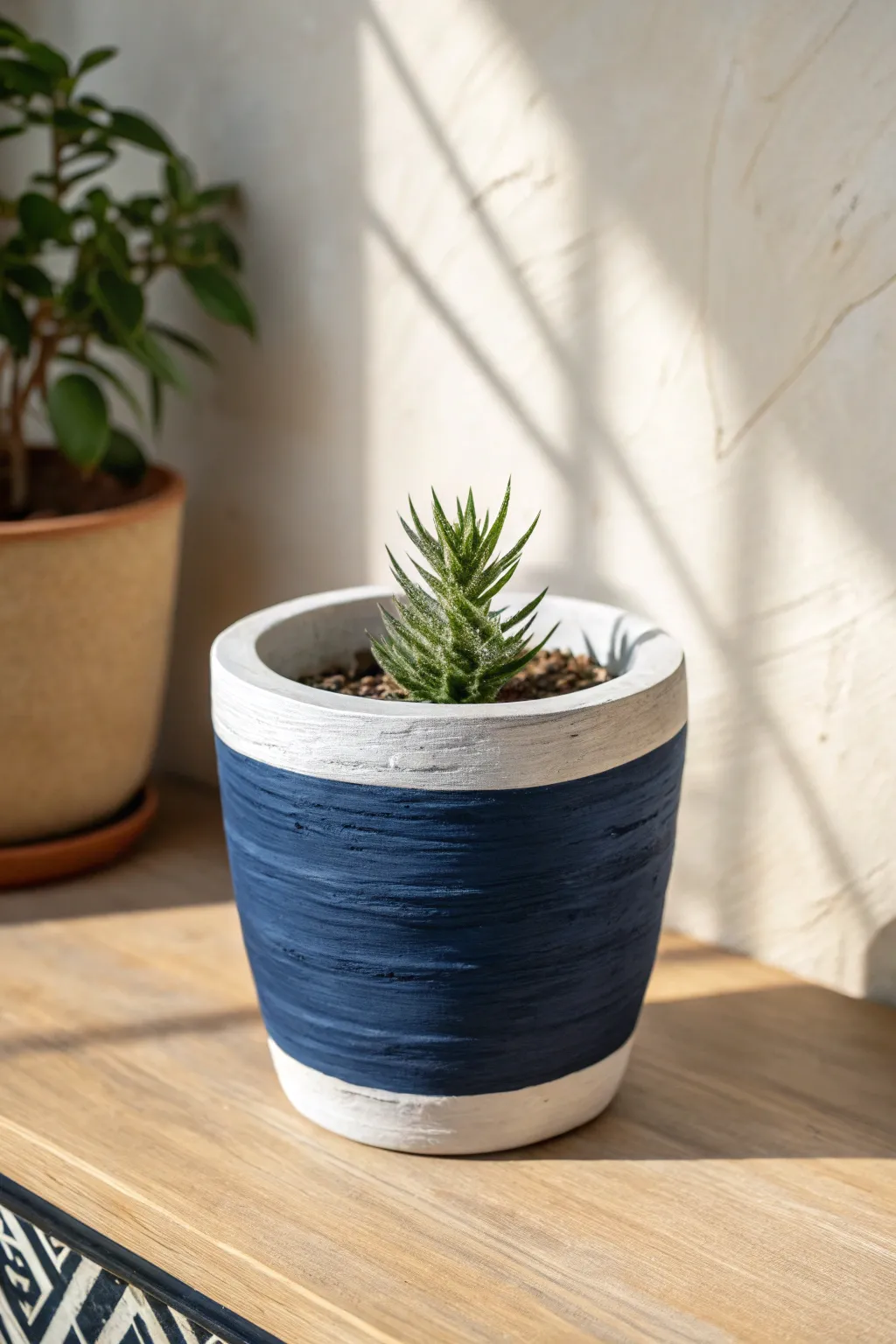 A classic solid-color clay pot in deep blue, styled with a simple plant for crisp modern calm.