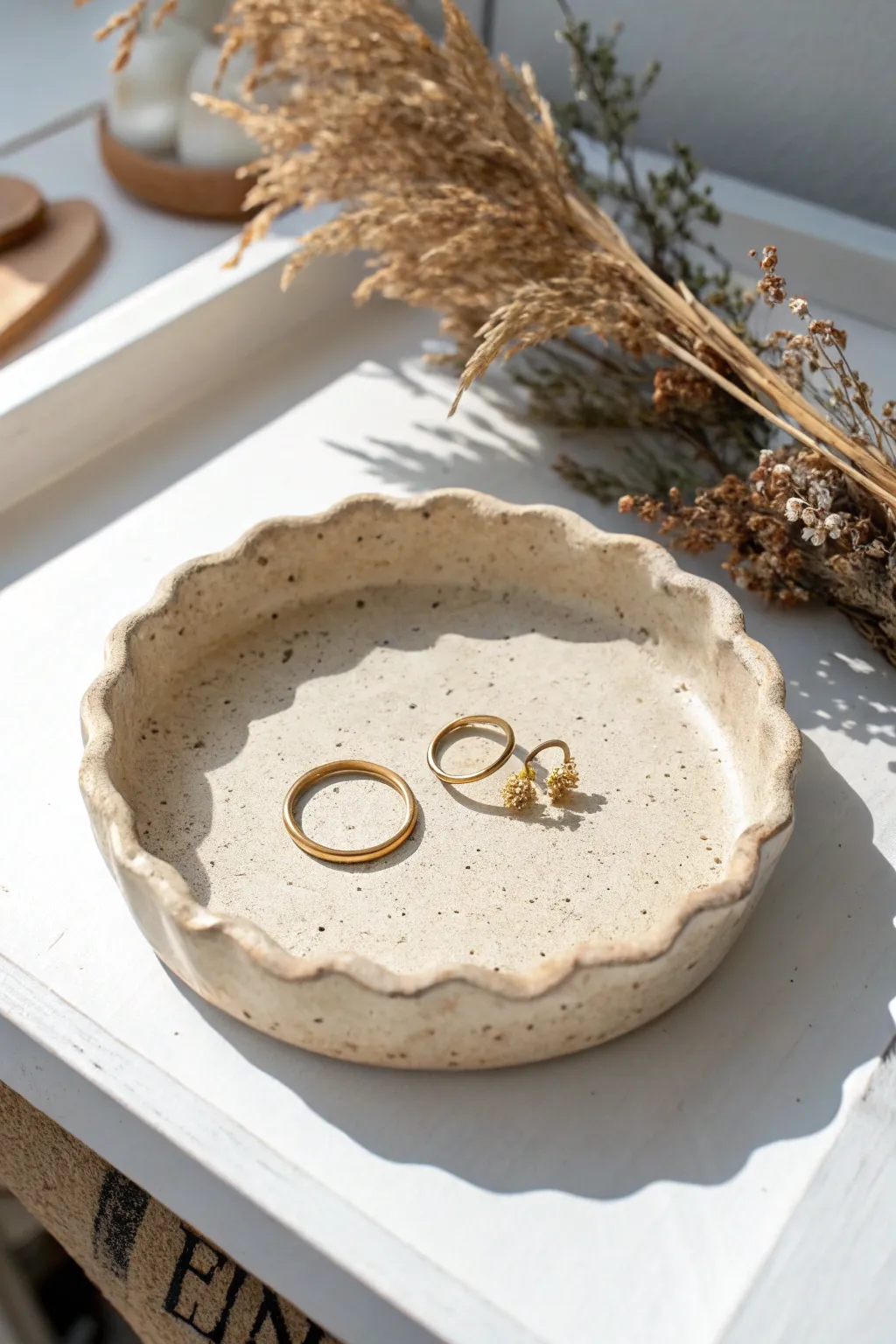 Organic round clay trinket tray with soft wavy edges, styled with rings and tiny studs