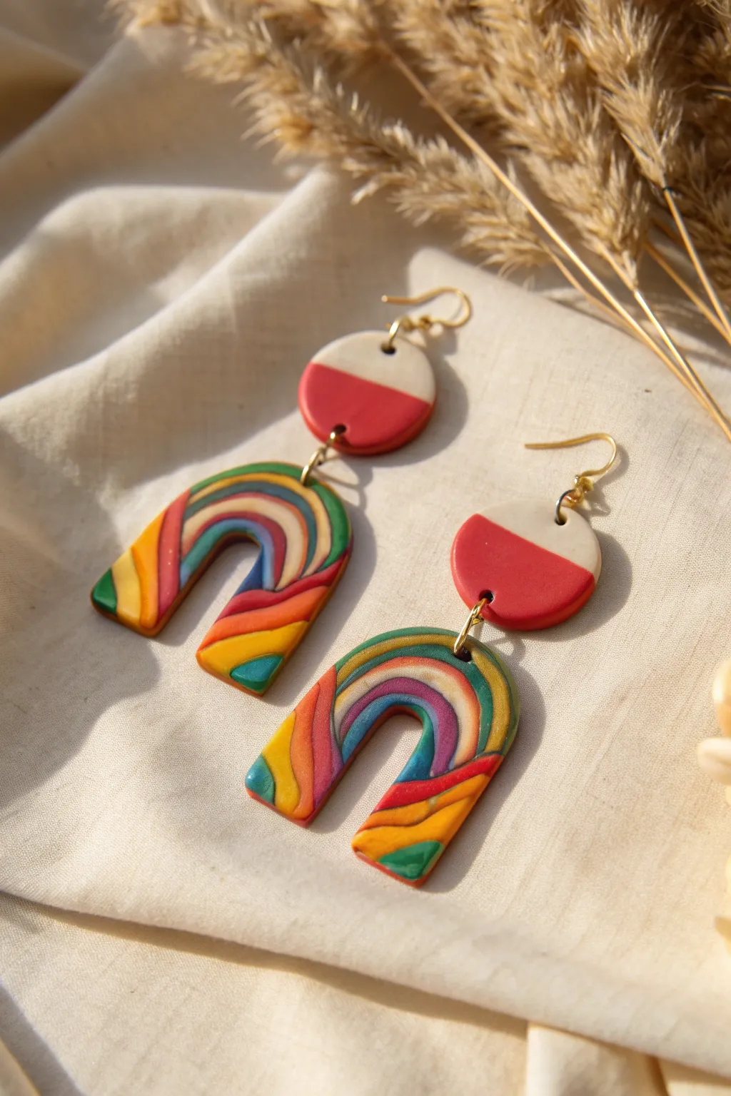 Bold rainbow swirl clay earrings on a neutral linen backdrop, soft light, crisp contrast.