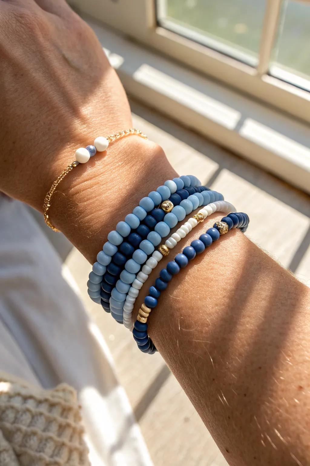 Classic blue heishi stack in sky-to-navy tones, minimalist accents, bright natural light