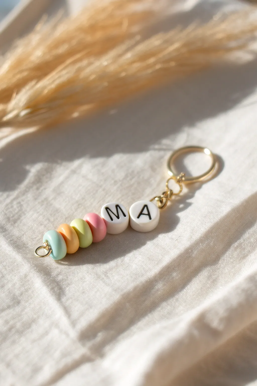 Pastel rainbow clay bead keychain with a simple name stack, bright minimalist style for Pinterest.