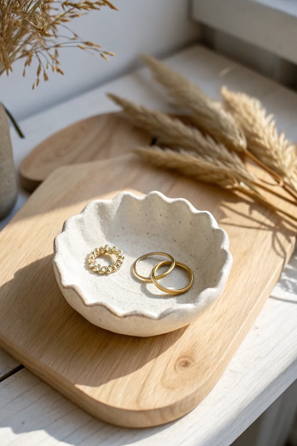 Classic air-dry clay trinket dish on pale wood, styled with rings for a soft minimalist look.