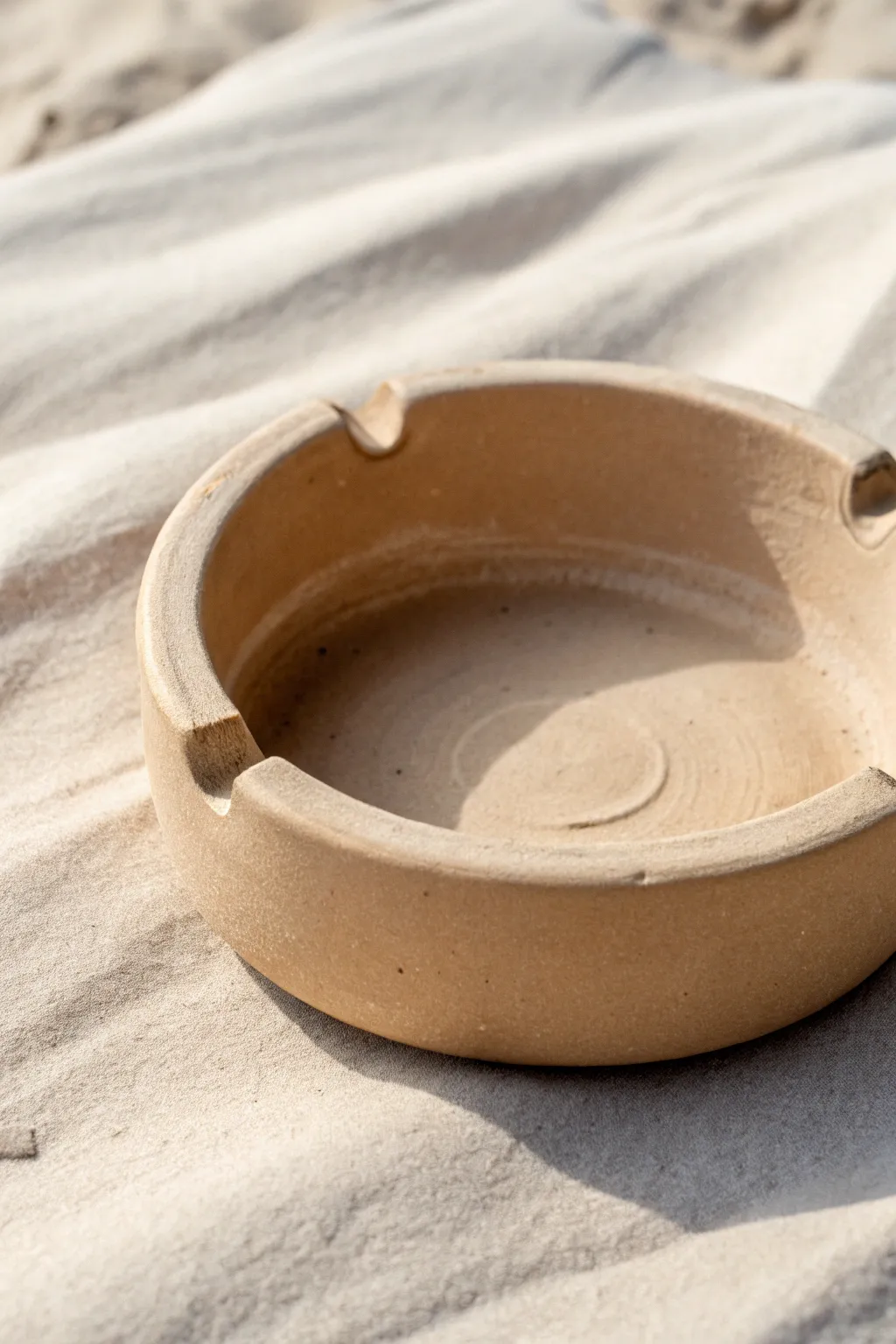 Minimal pinch-pot clay ashtray with clean notches and a soft matte neutral finish.