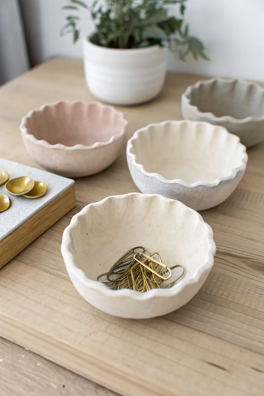 Simple air-dry clay pinch pots in soft neutrals, styled to hold rings and paper clips.