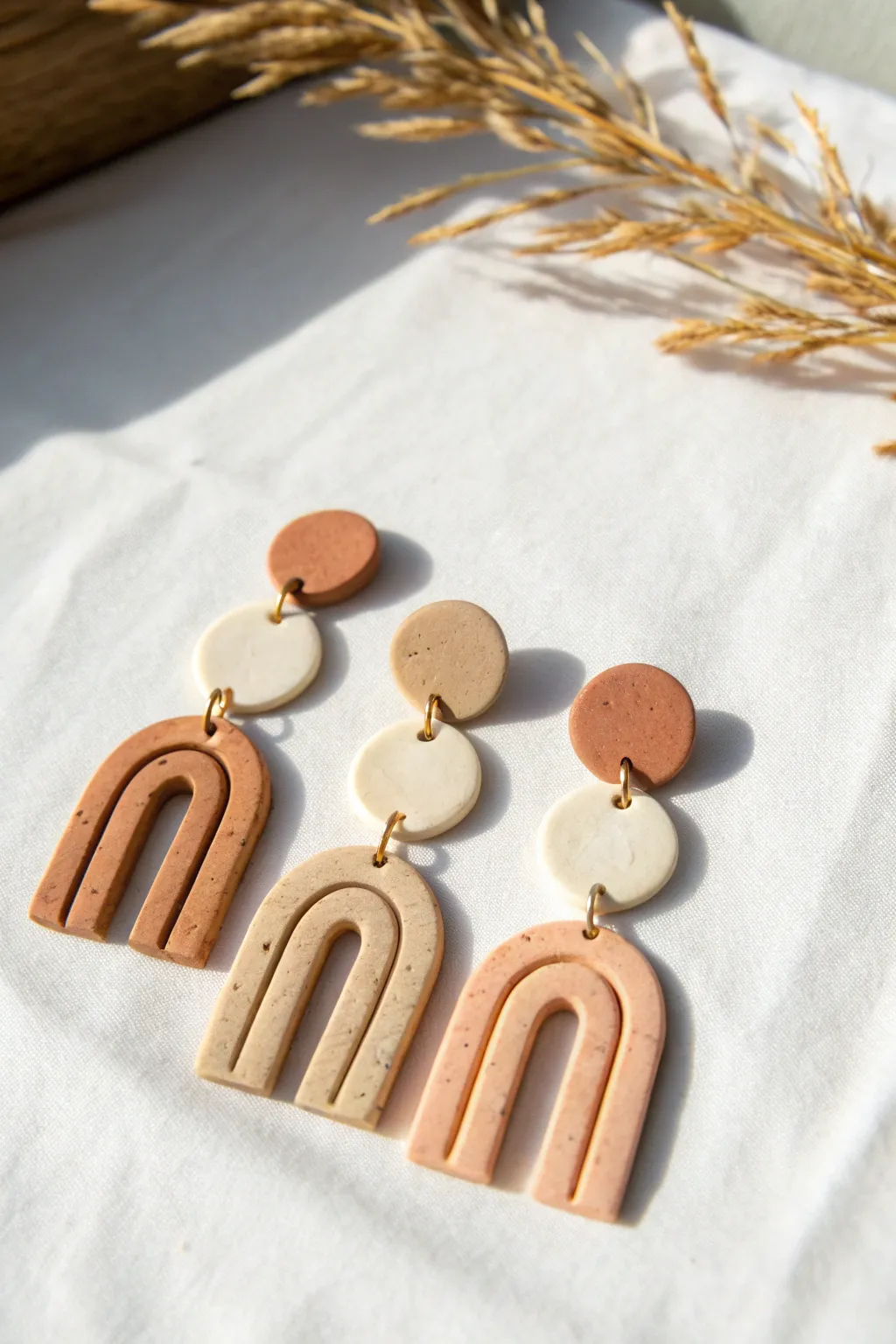 Classic arch polymer clay dangles in warm neutrals, matte finish, clean minimalist flat lay