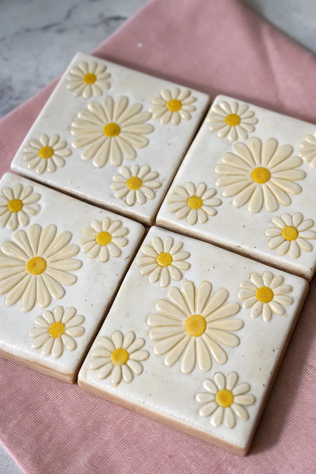 Stamped daisy clay tiles in white and sunny yellow, clean minimalist look with soft pastel contrast.