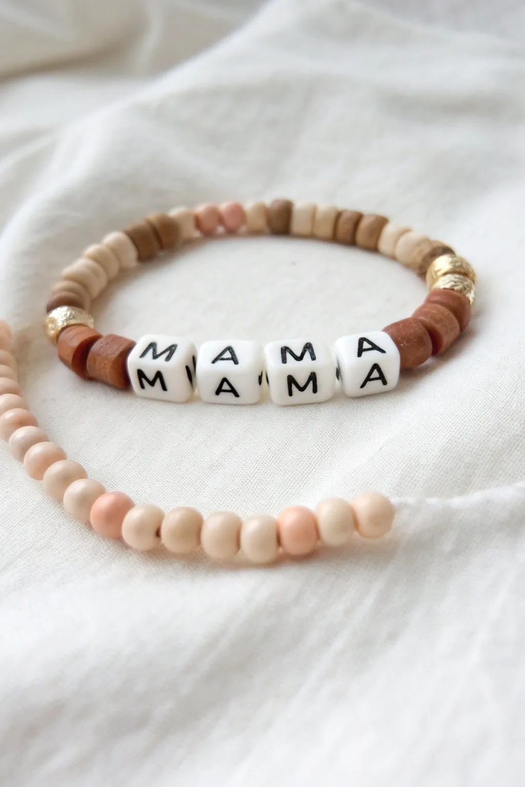 Classic neutral heishi bracelet with MAMA center and tiny hearts, a sweet Mothers Day gift.
