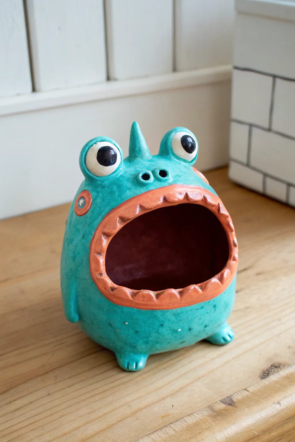 Classic open-mouth pinch pot monster with chunky teeth and big eyes, playful yet minimalist