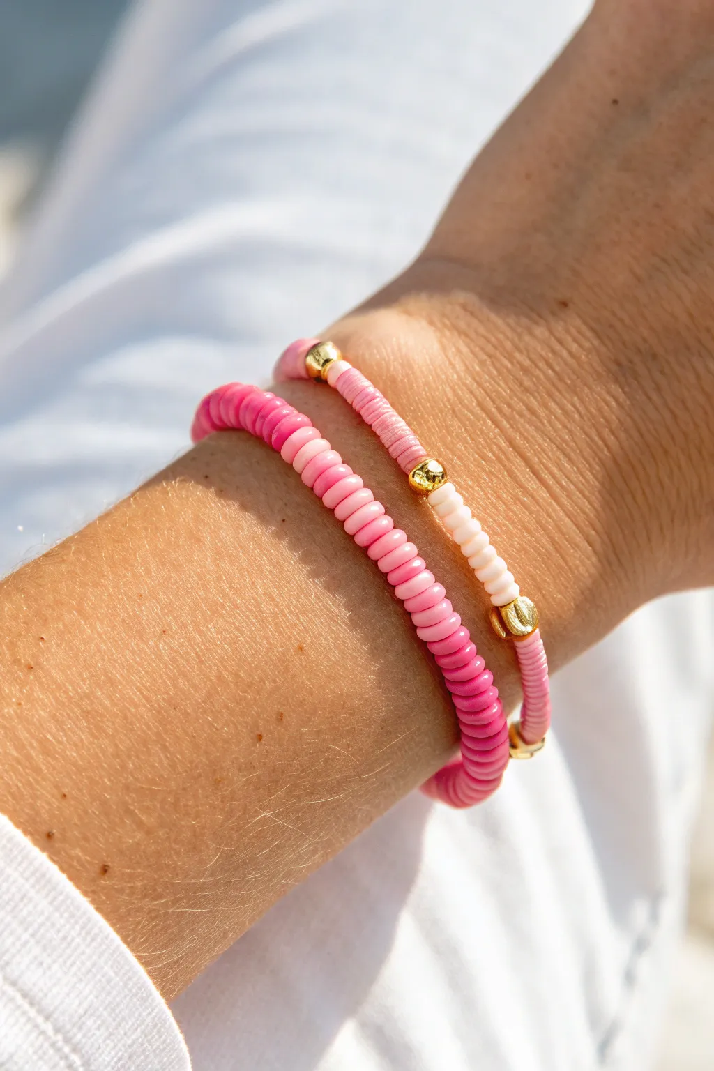 Classic pink ombré heishi bracelet with tiny gold spacers, bright natural light, clean minimalist vibe.
