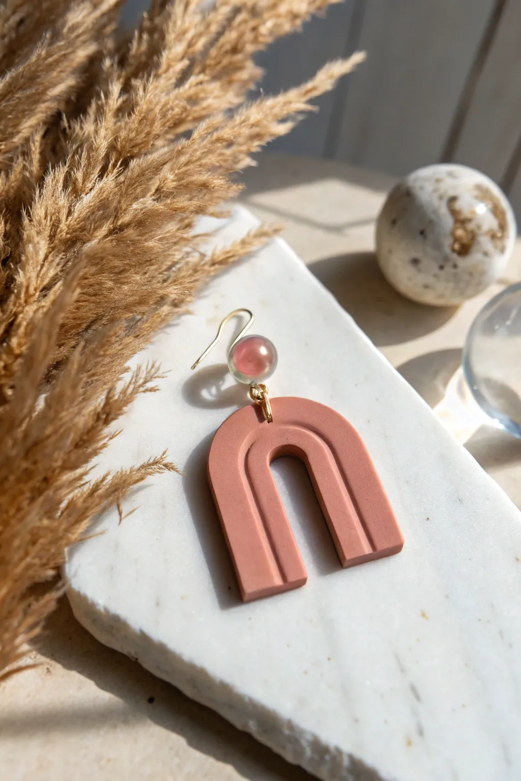 Geometric polymer clay earring topped with a crystal-clear resin dome for sleek shine.