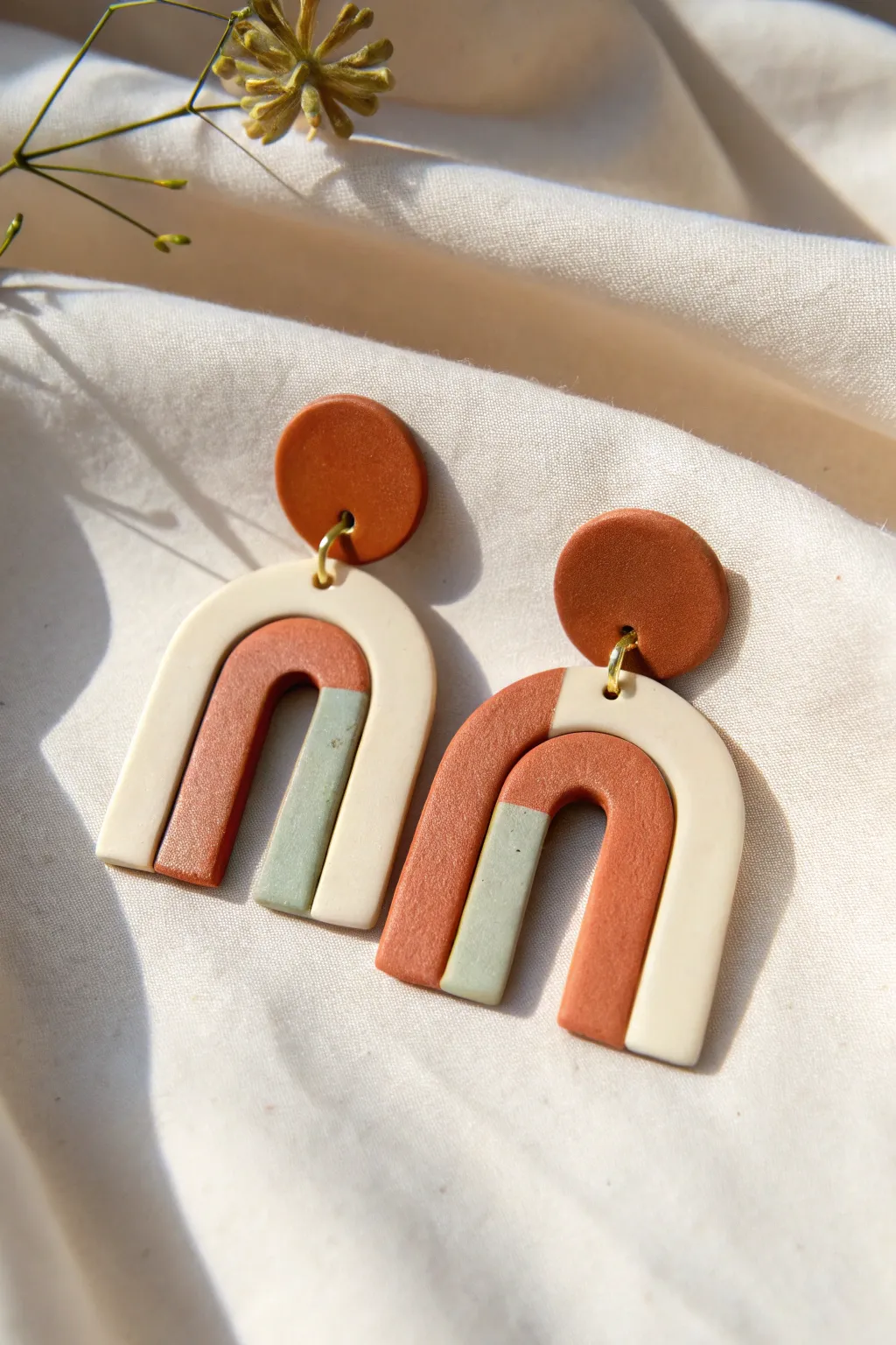 Modern arch polymer clay earrings in bold minimal tones, matte finish, clean Scandinavian style