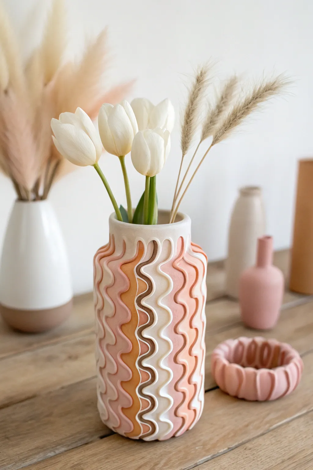Minimal glass vase with squiggle polymer clay wraps in soft tones, styled with tulips.