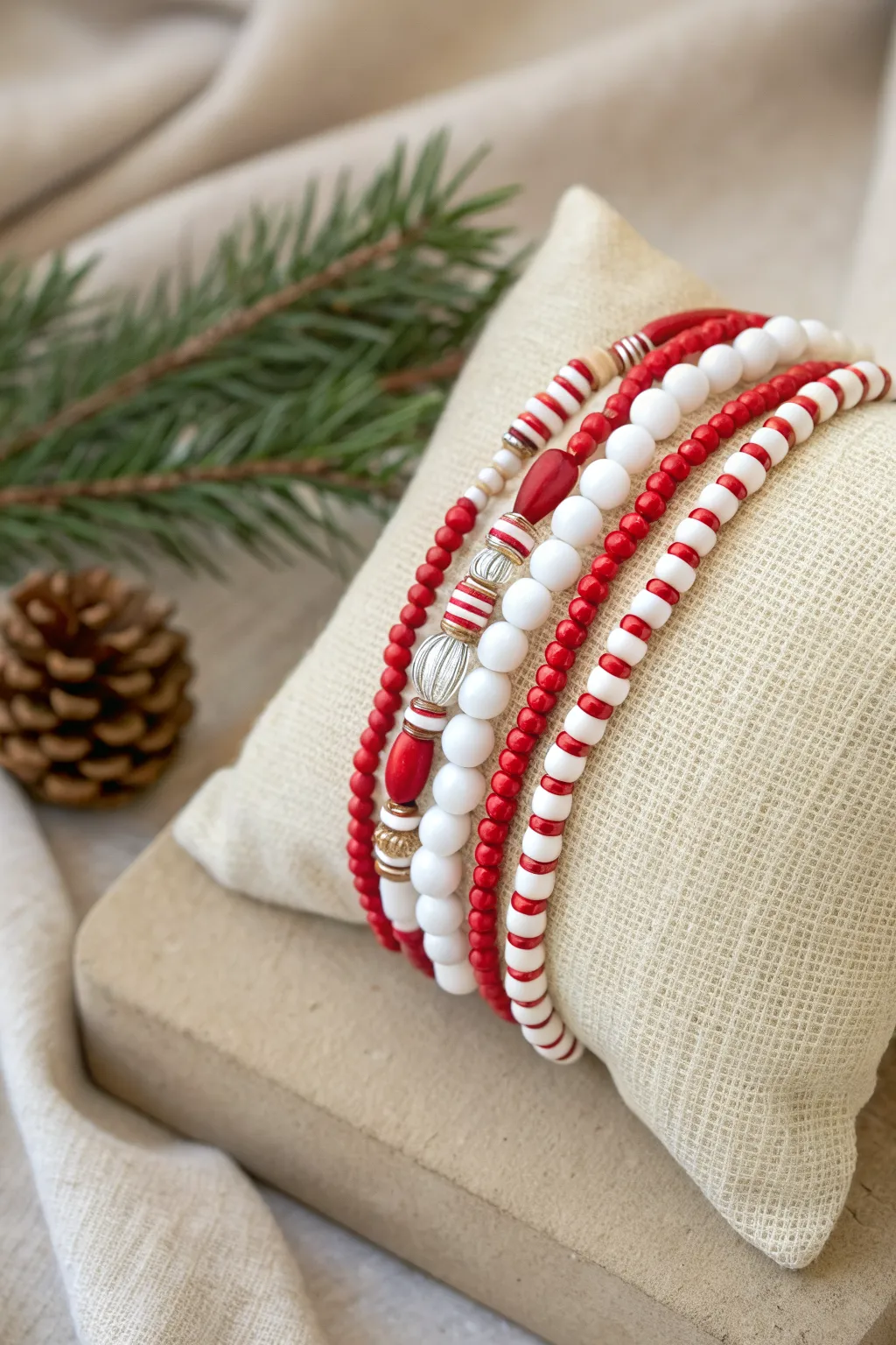 Classic candy cane heishi stack in red and white with a snowy strand, holiday minimal.