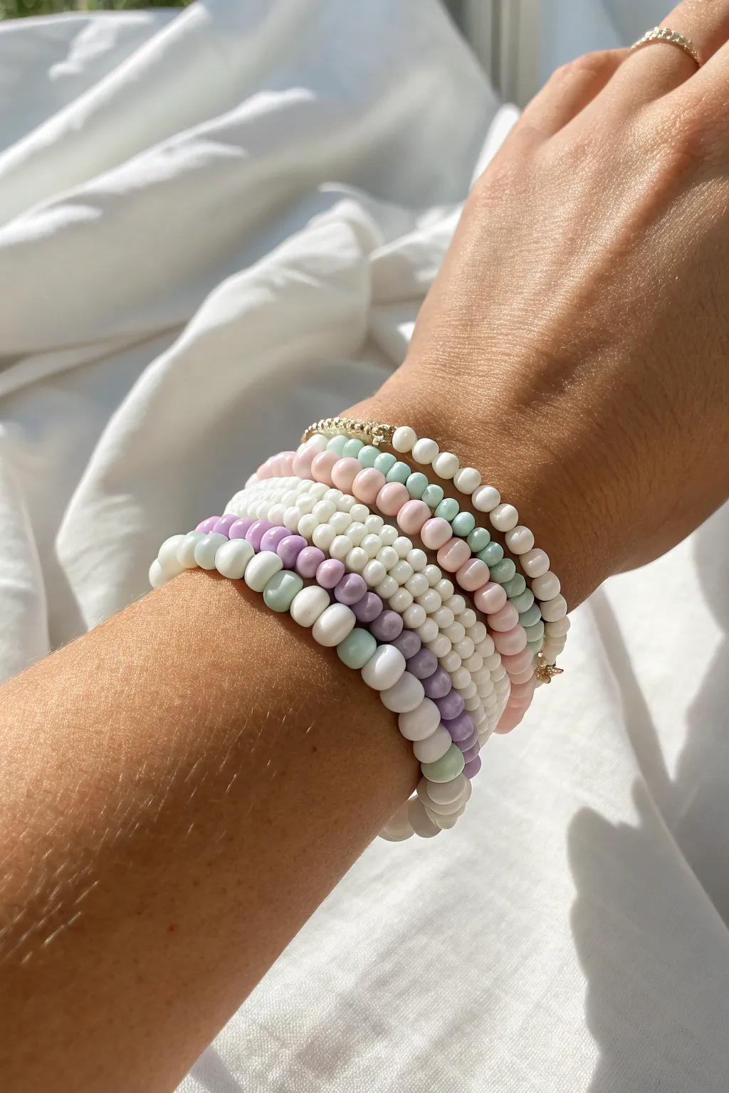 Sweet preppy stack: white heishi bracelets with pastel pops for an easy everyday look.