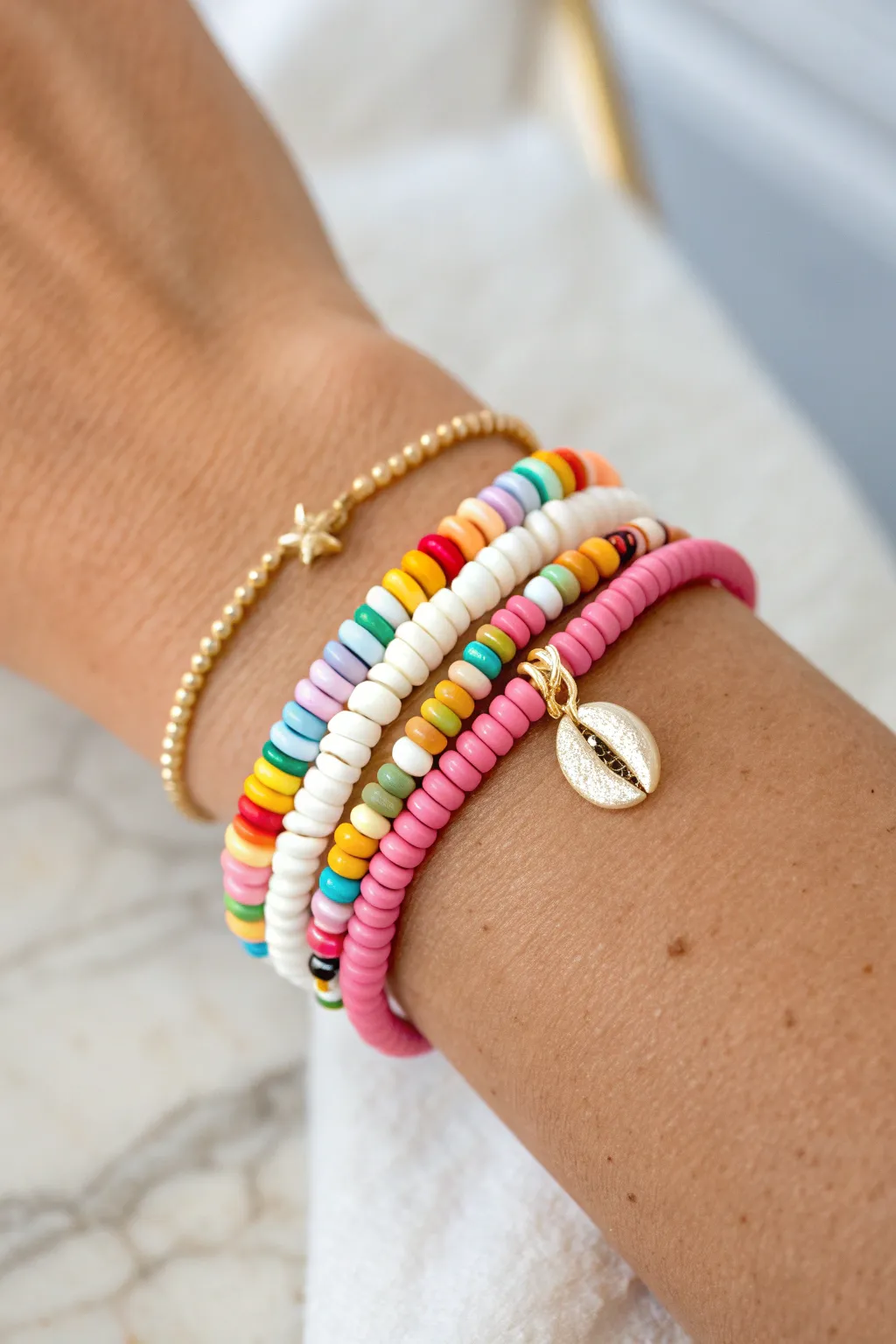 Classic rainbow heishi stack with subtle gold spacers and a tiny charm, clean and easy to wear.