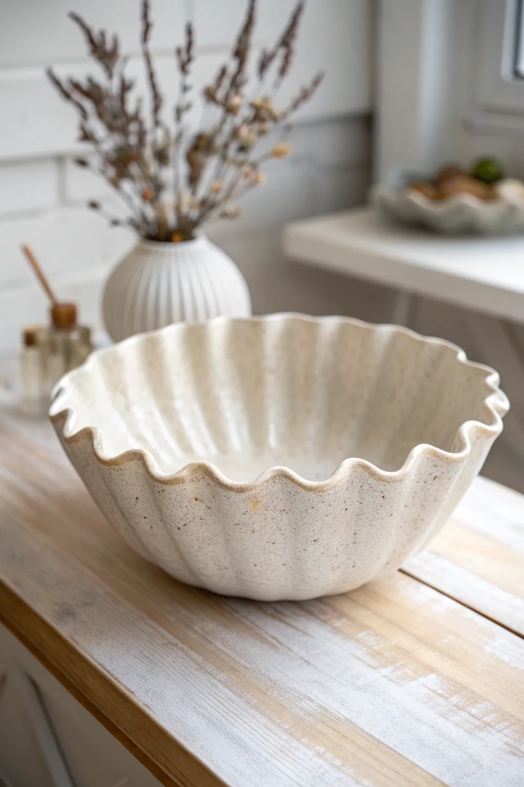 Minimal drape-molded wavy rim bowl, satin off-white glaze with shadows revealing soft folds.