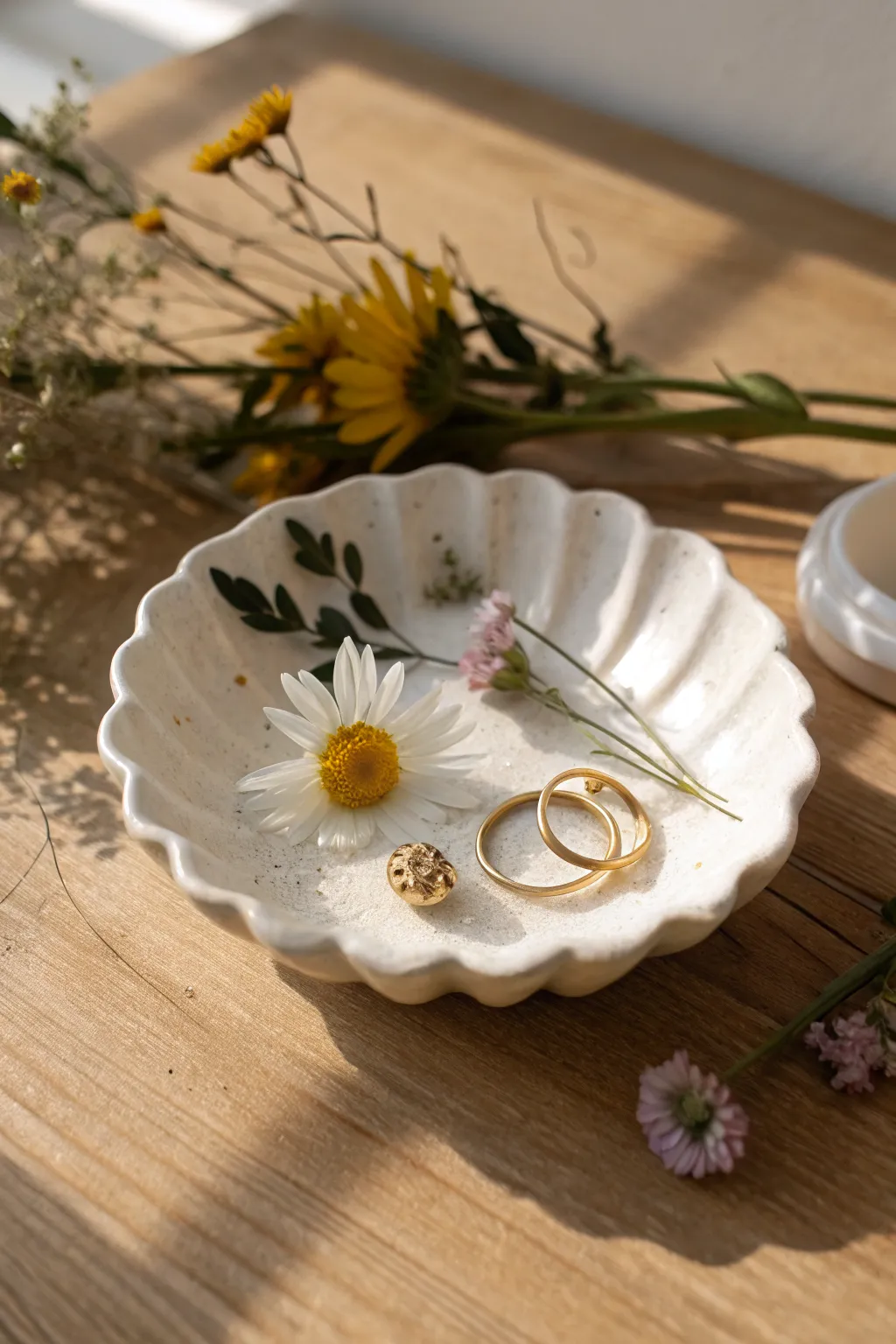 Pressed summer blooms in a scalloped clay dish, glowing in warm sun and made for tiny treasures.