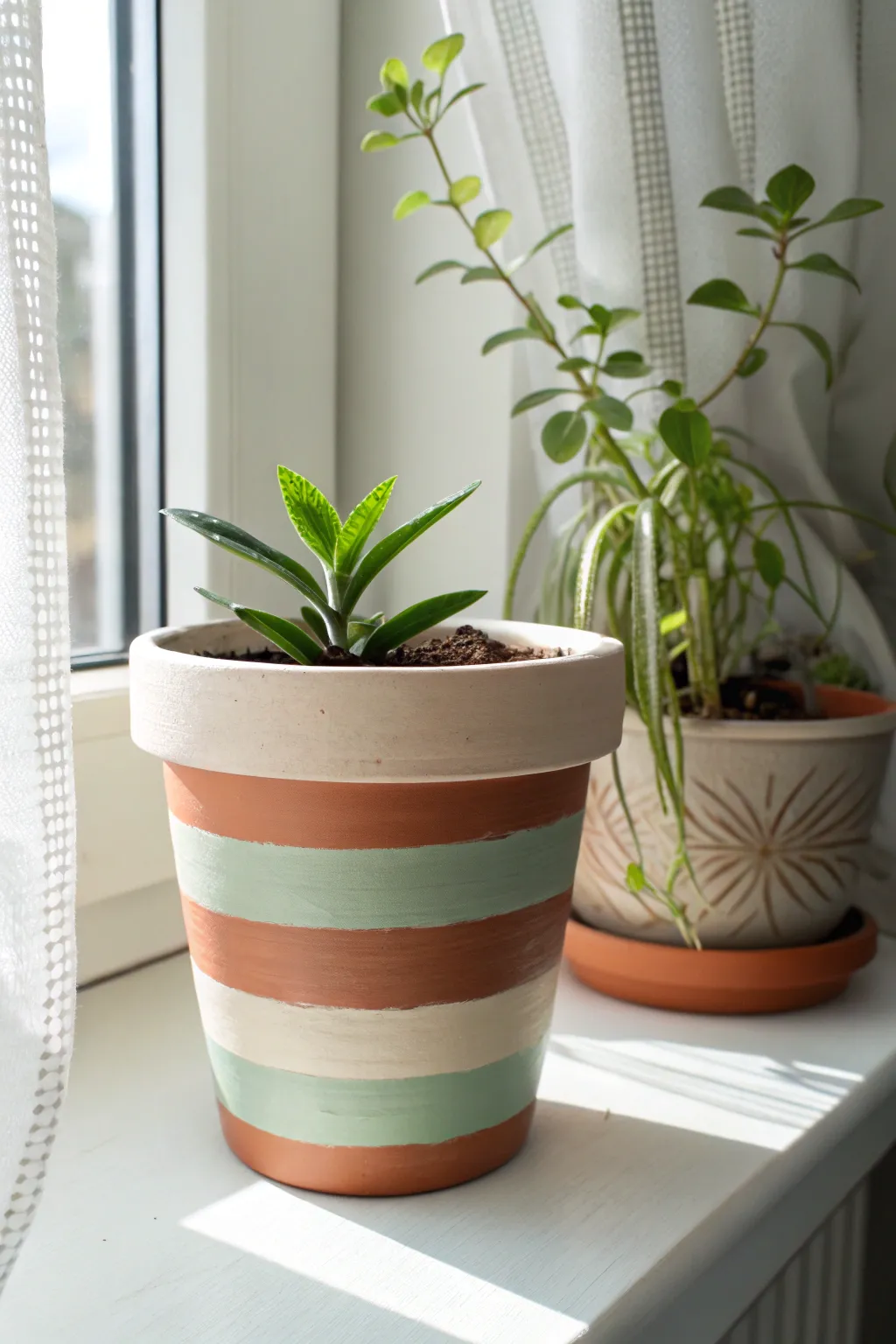 Classic tape-resist stripes transform a terracotta pot into a clean, boho-minimal statement.
