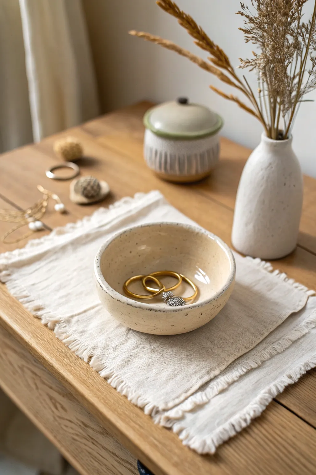 A simple handmade pinch pot bowl for rings and pins, perfect for a calm minimalist bedside setup.