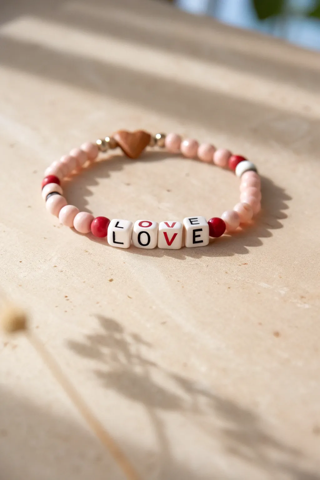 Minimal Valentine clay bead bracelet with centered LOVE beads and tiny red and white hearts.
