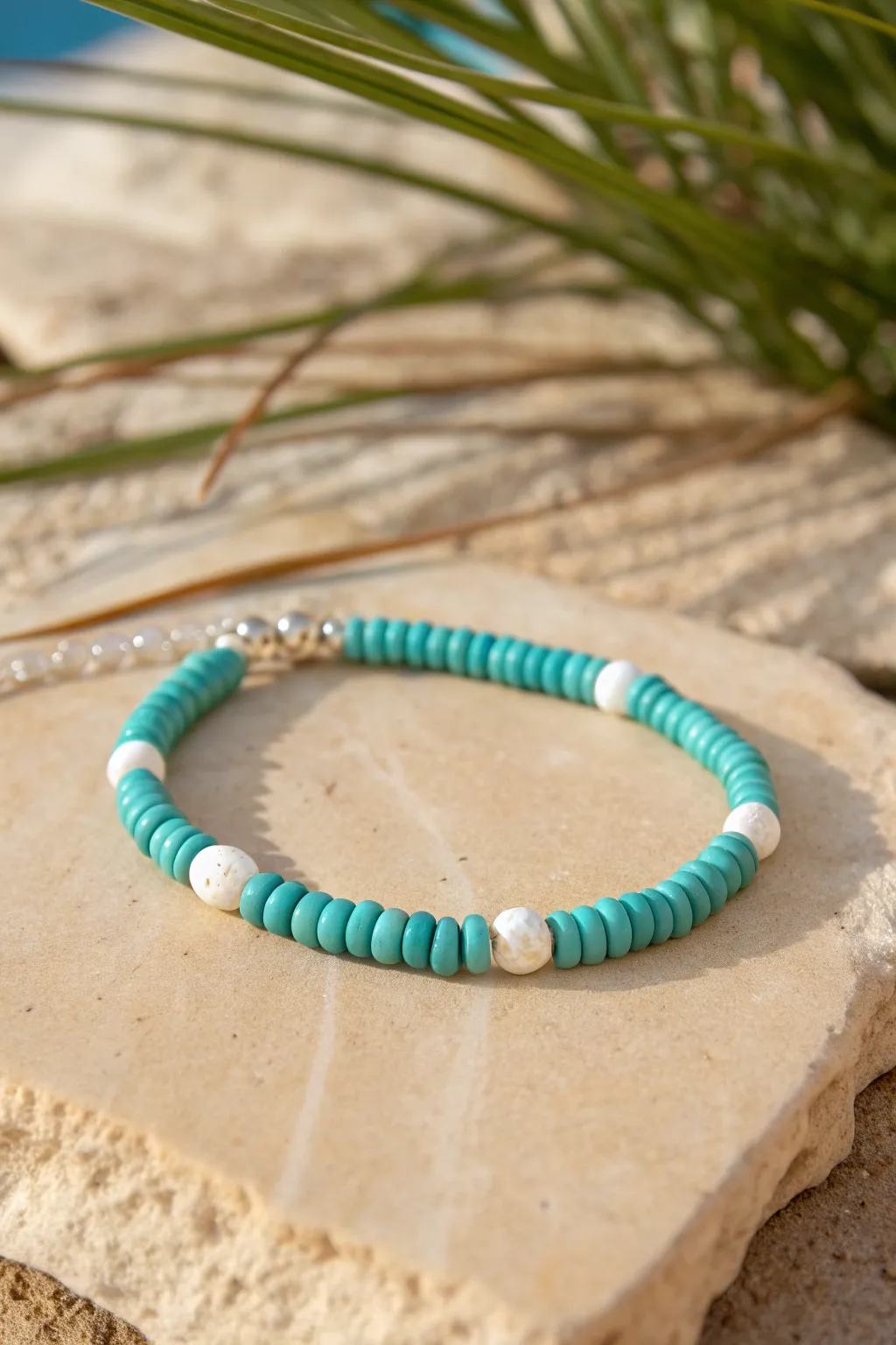 Turquoise and white heishi clay bracelet on sandy stone for a clean, classic Western look
