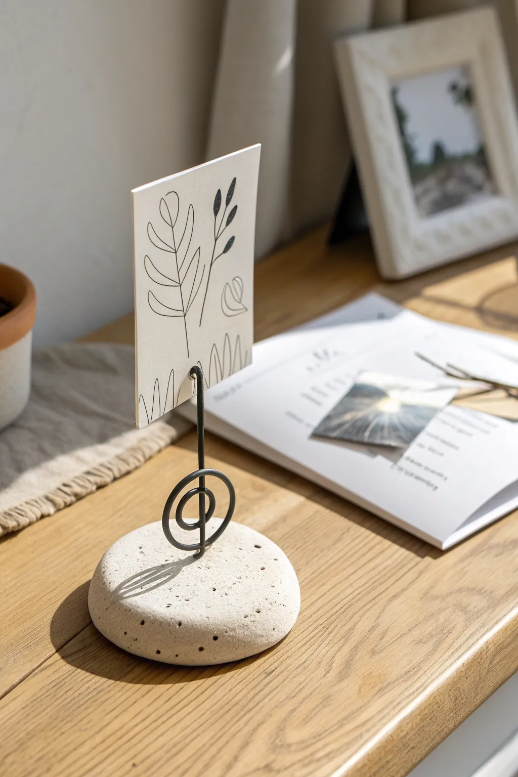 Minimal air dry clay photo holder with wire slot, styled in calm neutral Scandinavian tones.
