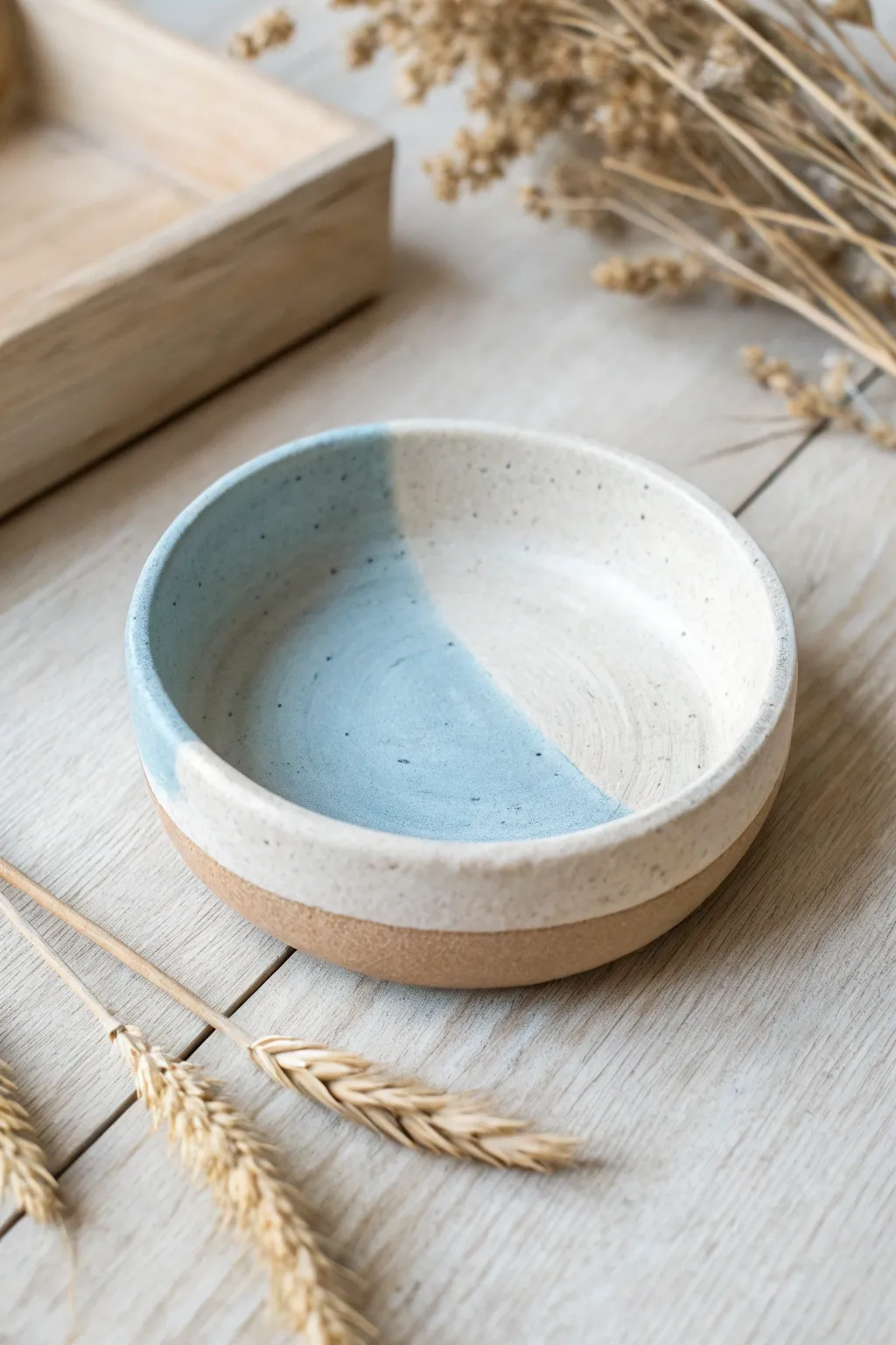 Minimal two-tone dip-painted air dry clay trinket dish in cream and muted blue.