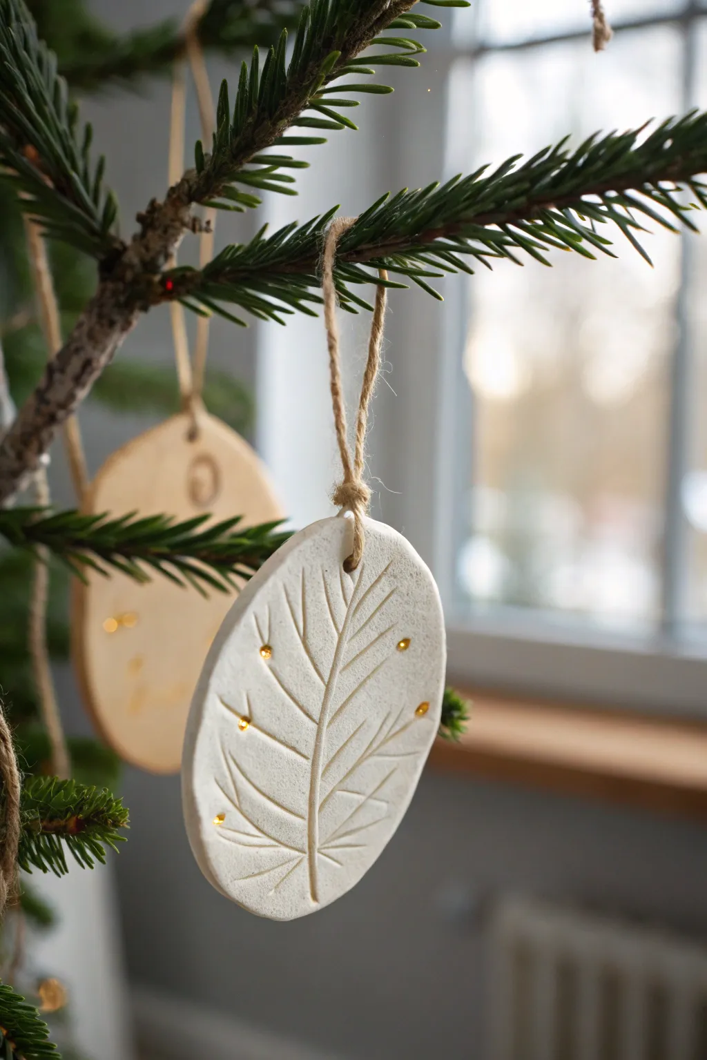 Soft white leaf-vein clay ornament with subtle gold highlights, minimalist Scandinavian boho elegance.