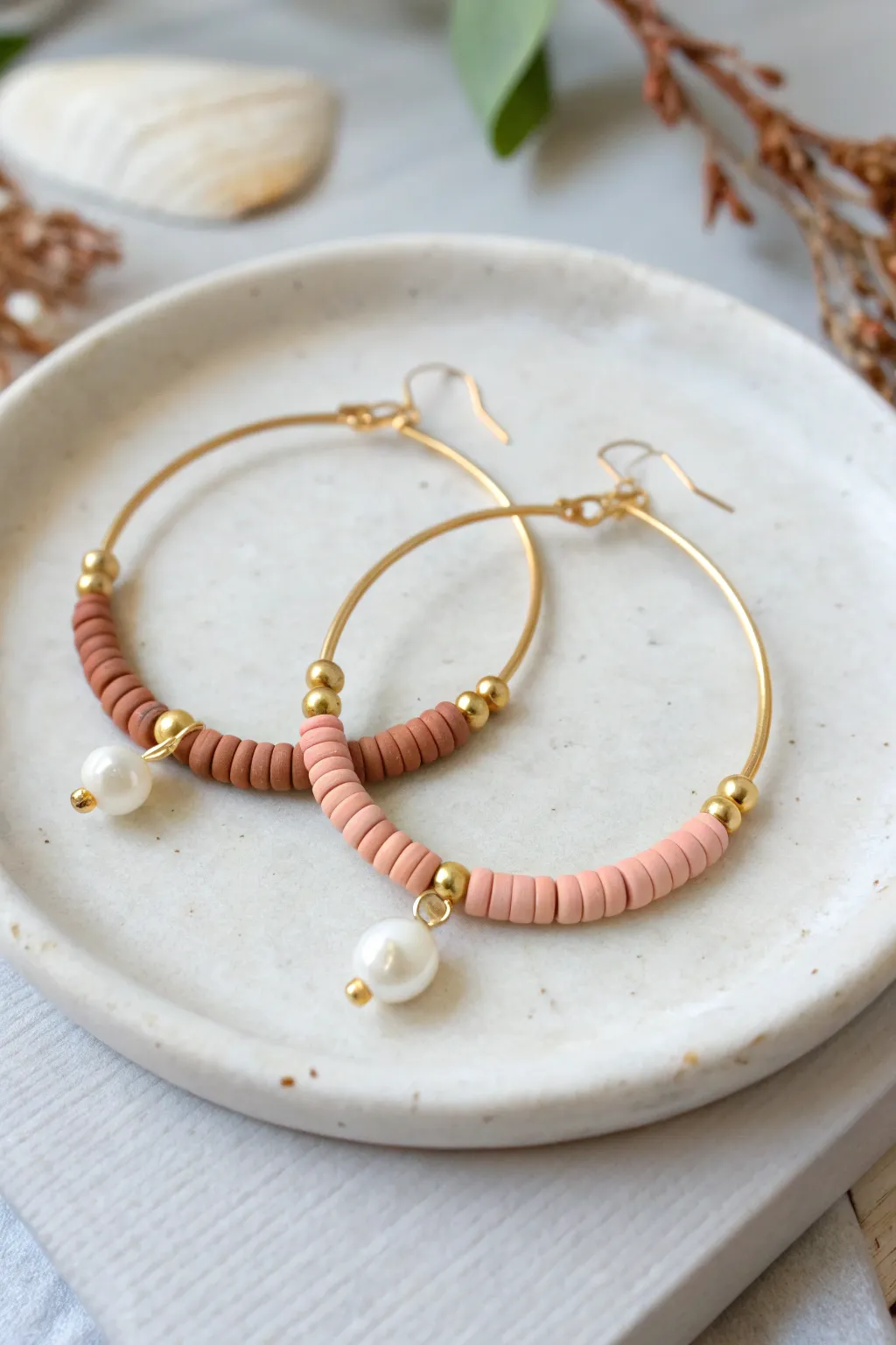 Matte heishi beads meet tiny pearl accents for a clean, modern hoop earring look.