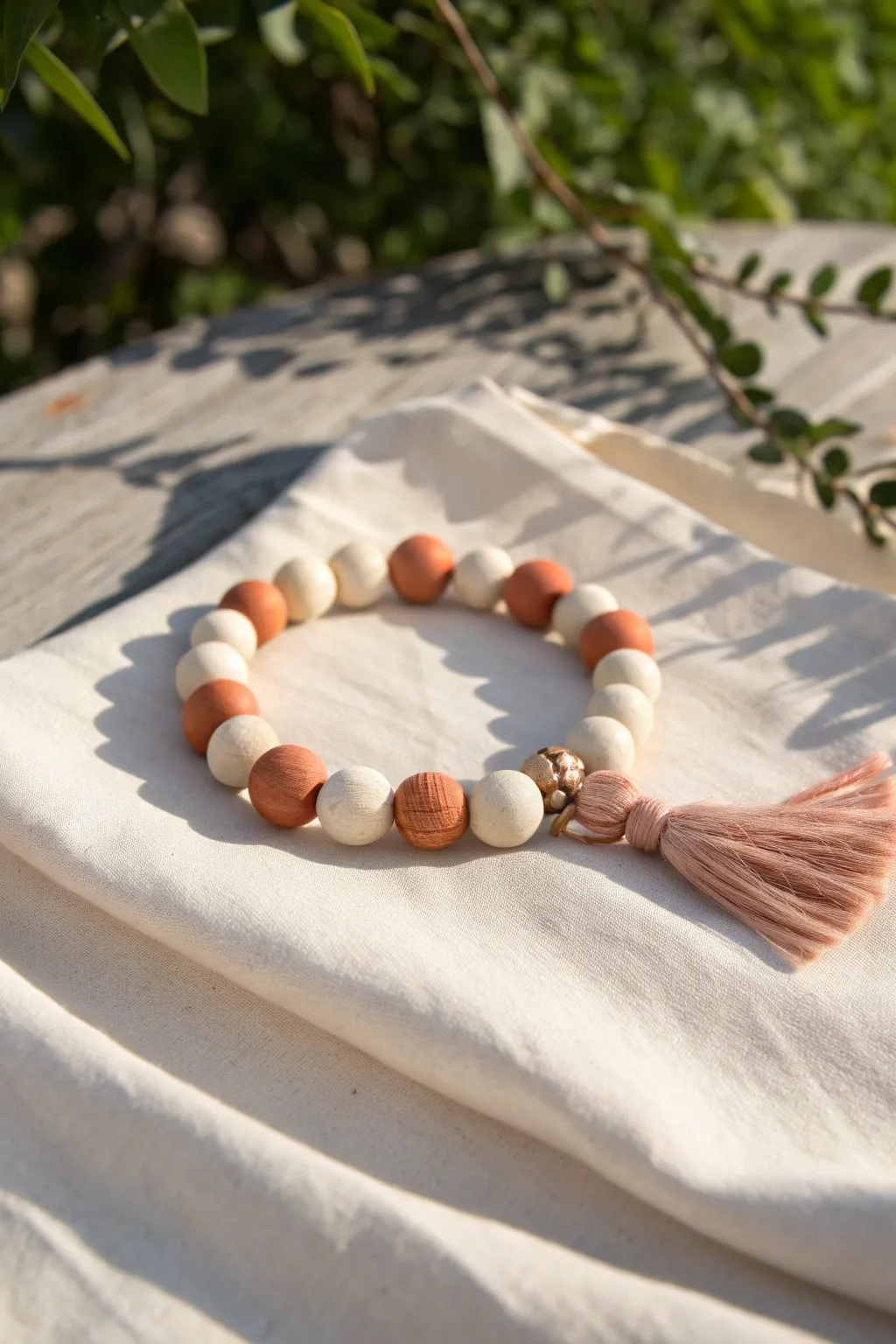 Summer festival clay bead bracelet with a simple tassel charm in soft, natural tones.