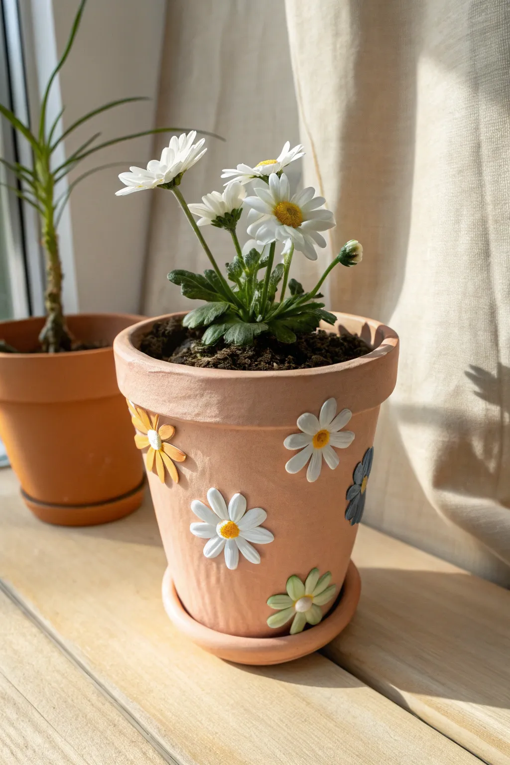 Cheerful clay pot with raised daisy appliqués and a blooming daisy, minimalist boho vibe.