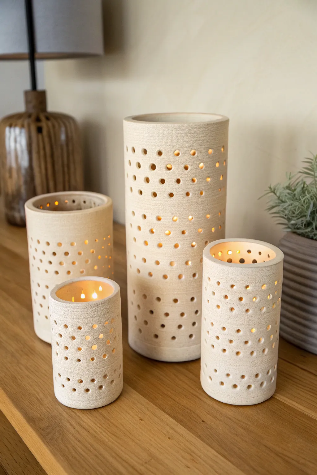 Three coordinated clay luminaries in varying heights, casting a calm, intentional shadow glow.