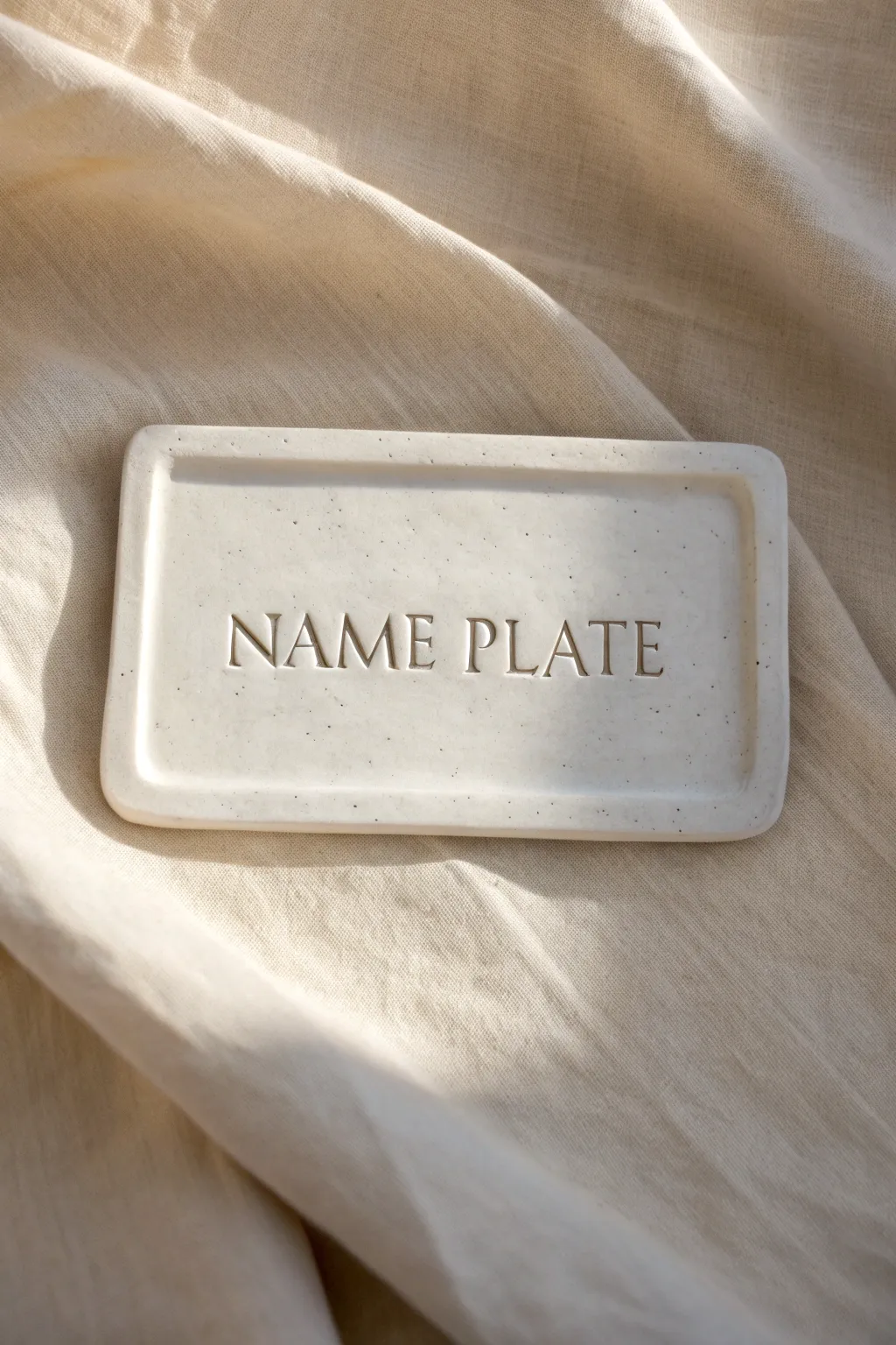 Minimal clay name plate with engraved monogram and charcoal paint fill for crisp contrast.