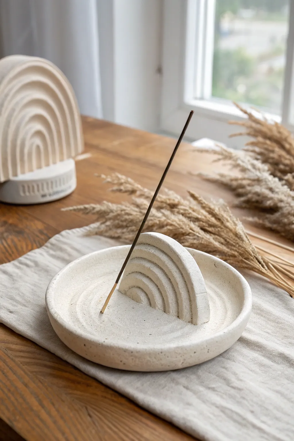Sculpted air dry clay incense holder with soft curves, minimalist calm, warm natural light