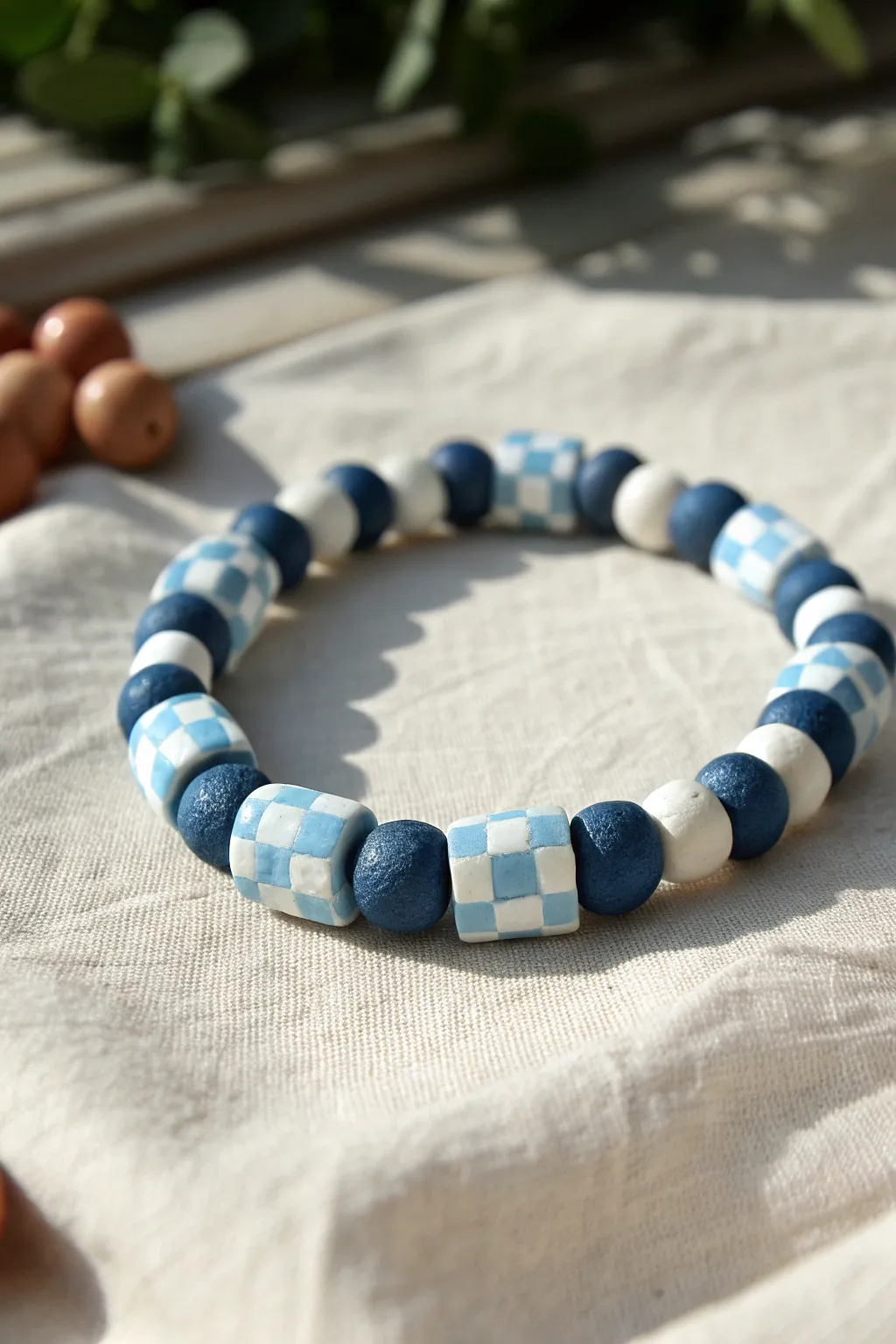 Blue checkerboard clay bead bracelet laid flat in soft light for a clean, modern boho look