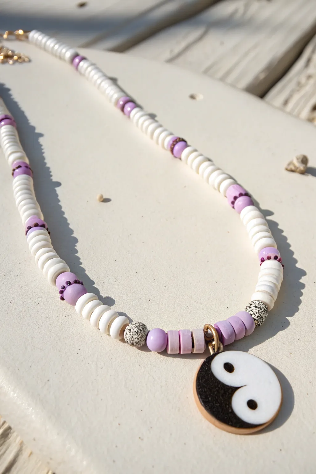 Clean pastel heishi necklace with a handmade yin-yang charm for minimalist boho vibes