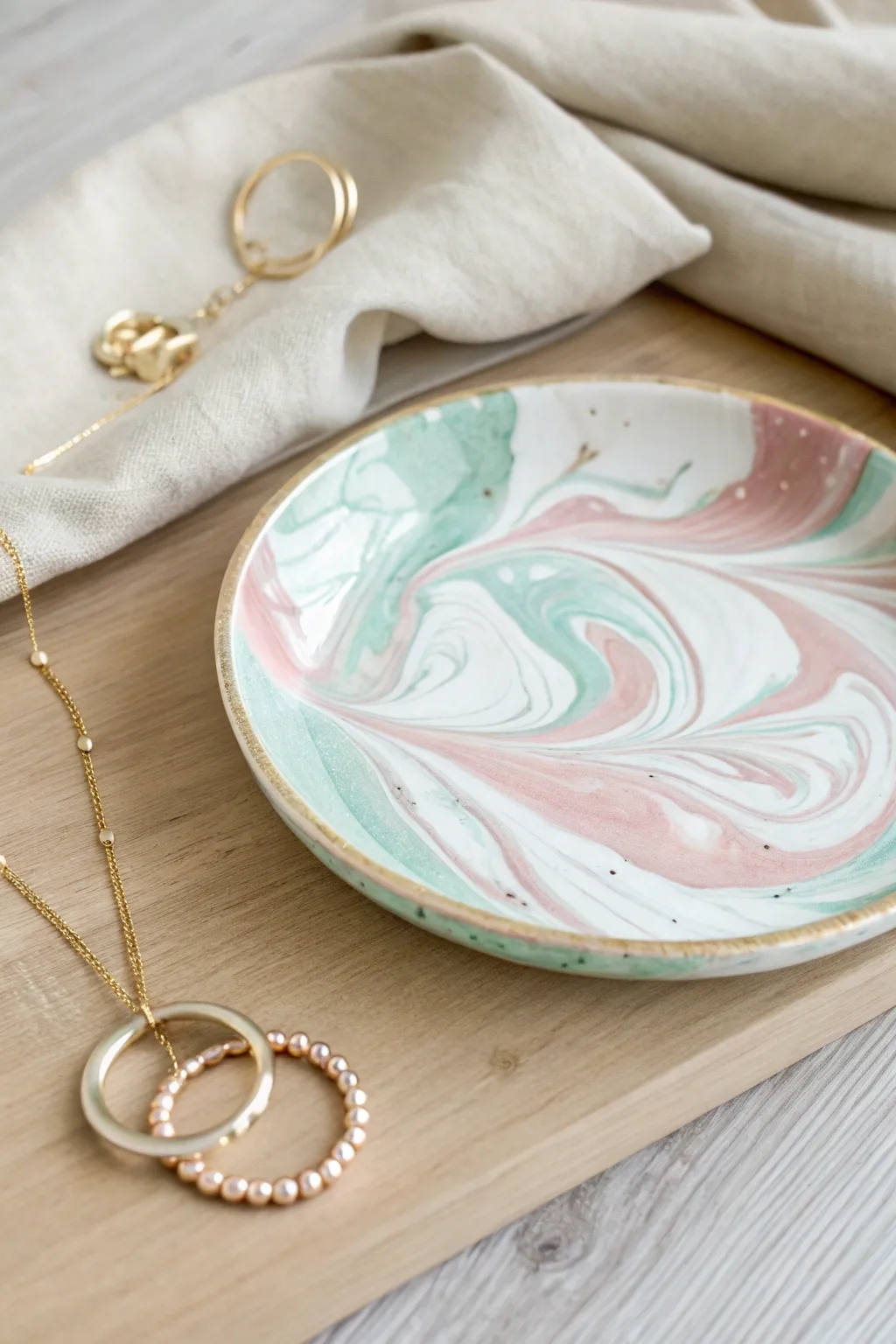 Pastel swirl marble trinket plate in blush and mint, glossy and ready for jewelry.