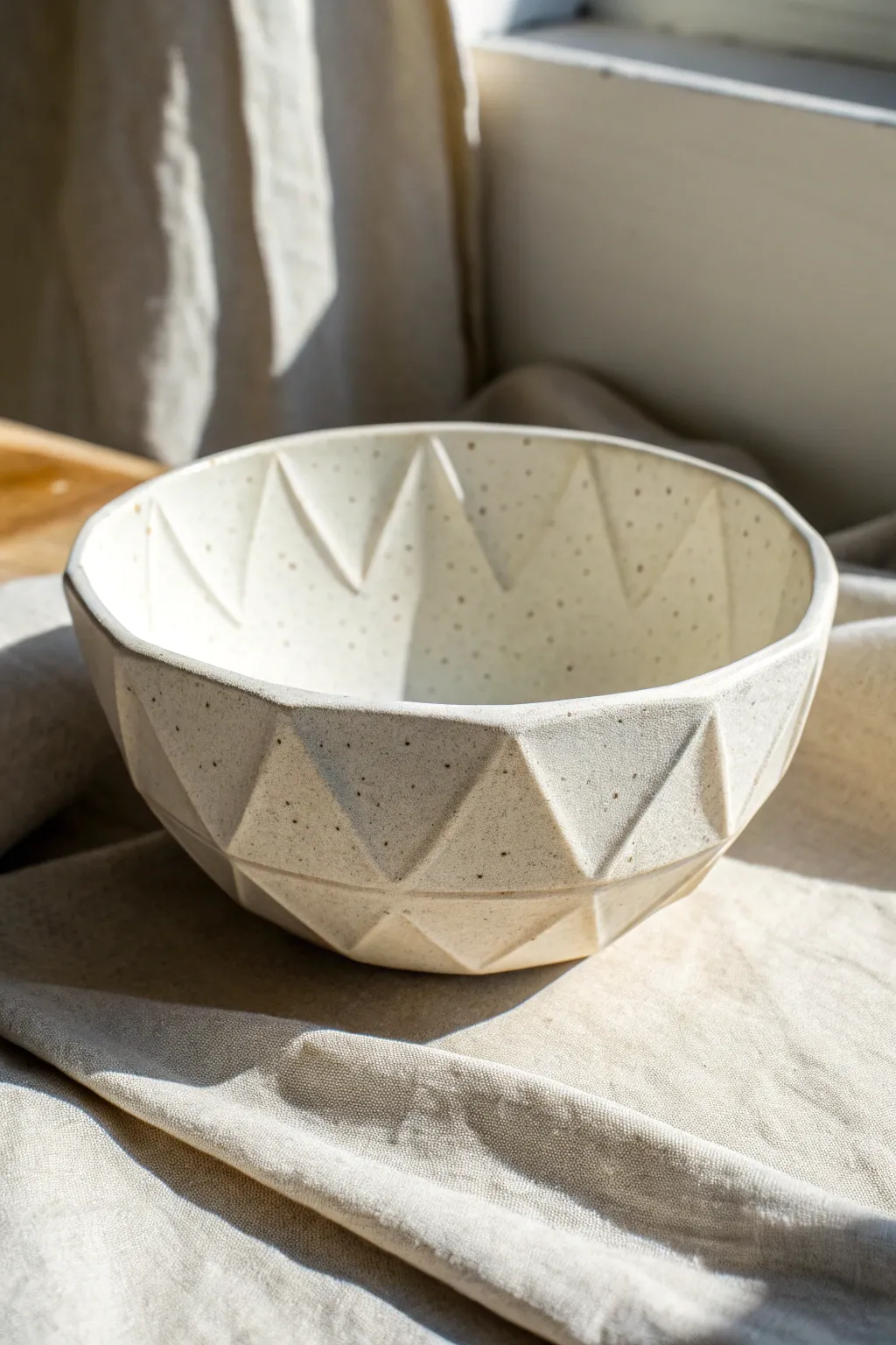 Matte faceted drape bowl with crisp fold lines, a minimalist statement of handmade texture