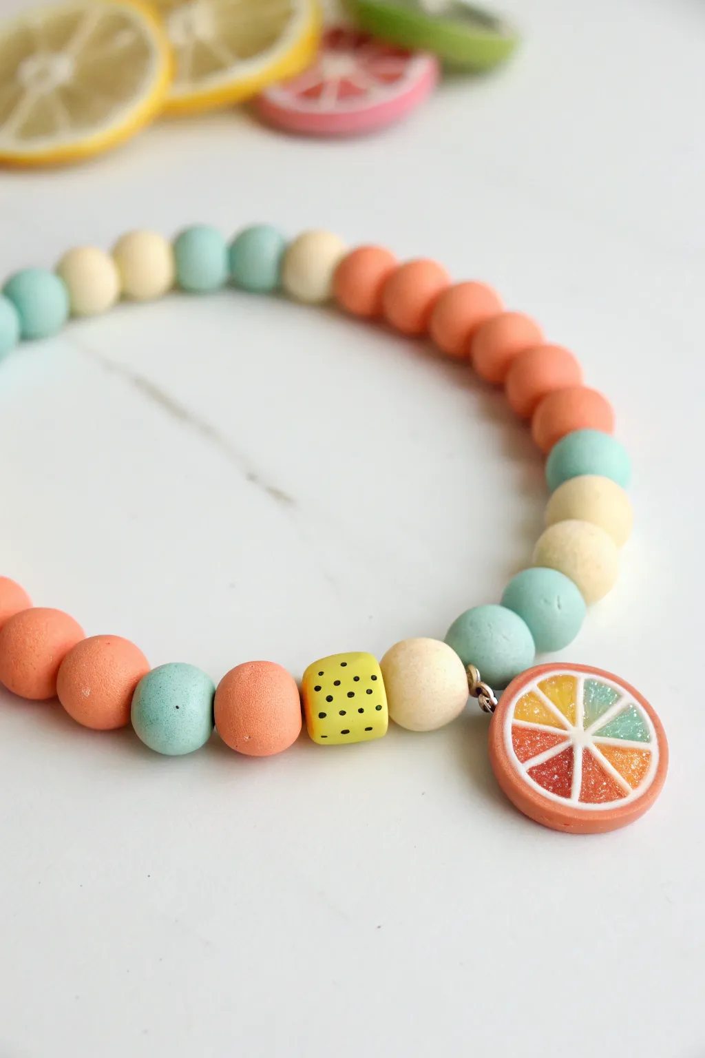 Summery clay bead bracelet with cute fruit slices, minimal palette, handmade and wearable.
