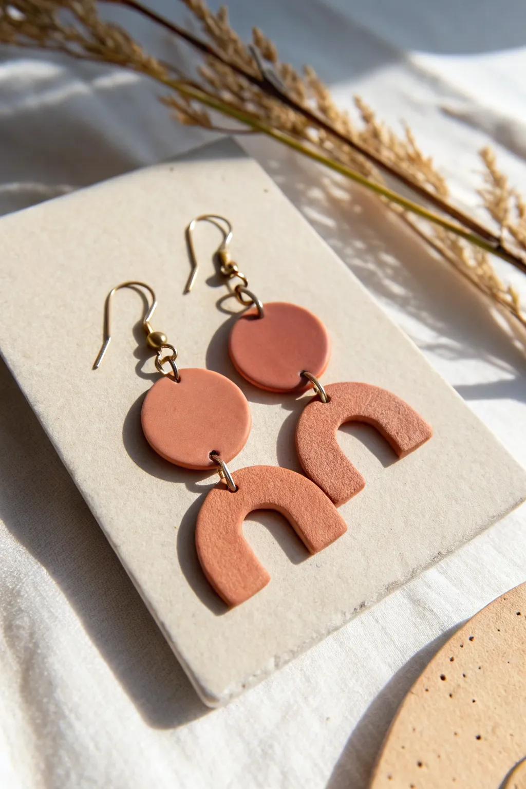 Simple geometric air-dry clay earrings in matte blush and terracotta, clean minimal and handmade.